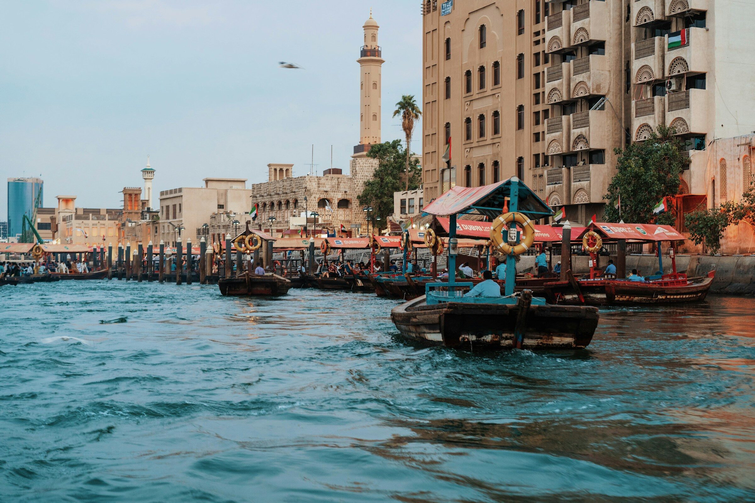 Boats on Dubai Creek near old buildings