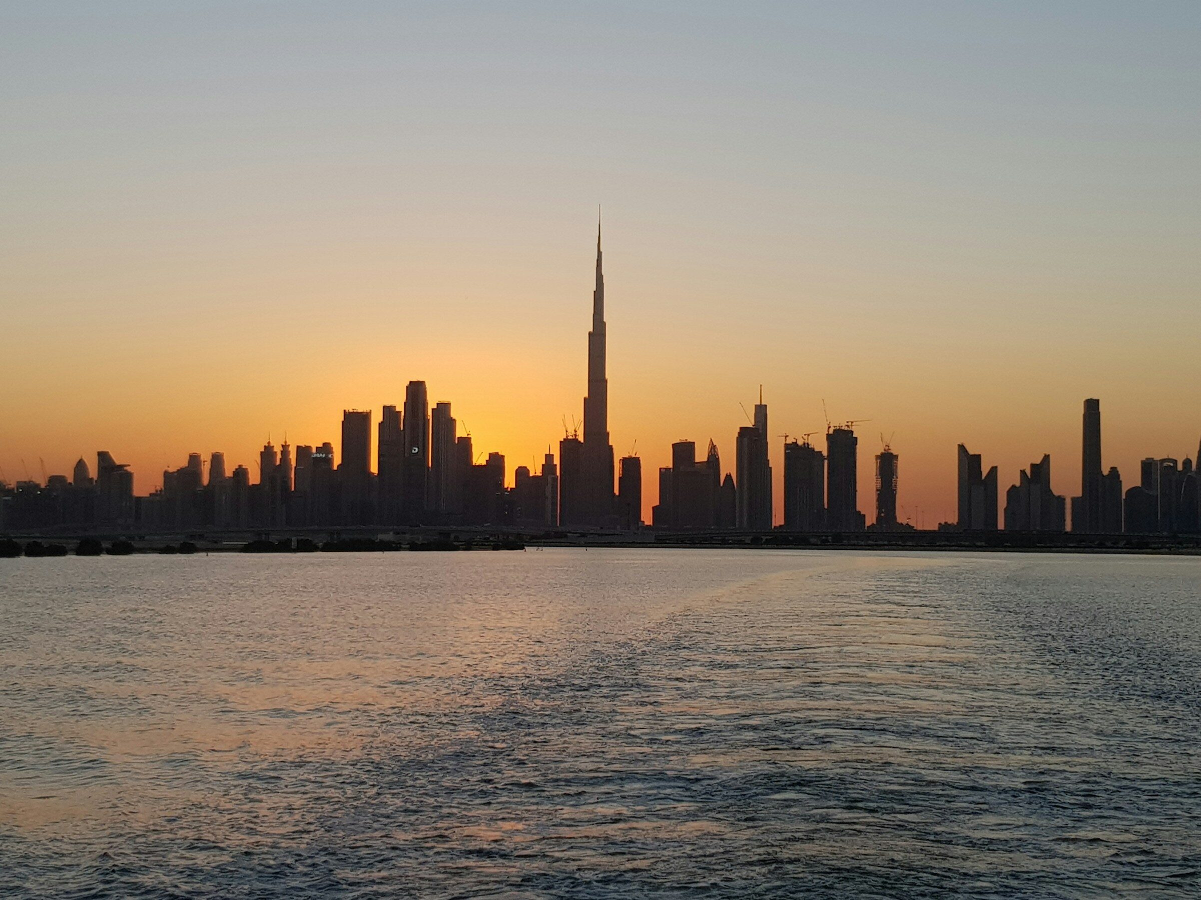 The Dubai skyline across the water at sunset