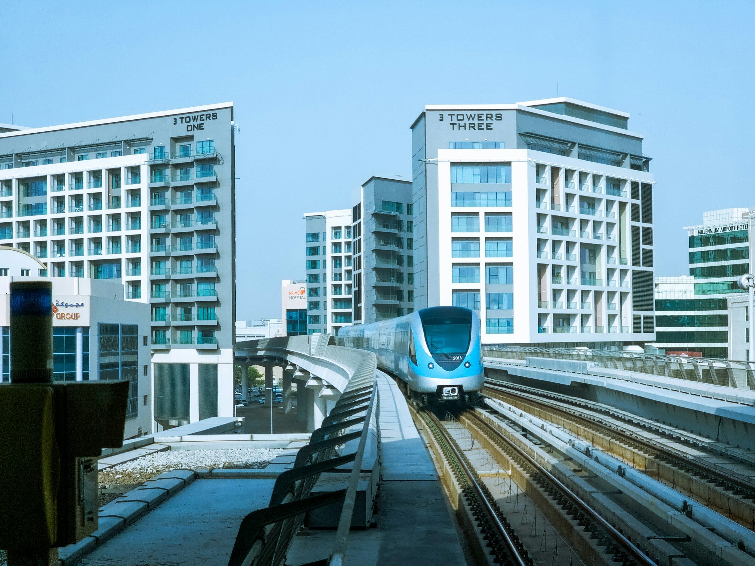 A Dubai Metro train travelling past high-rise towers