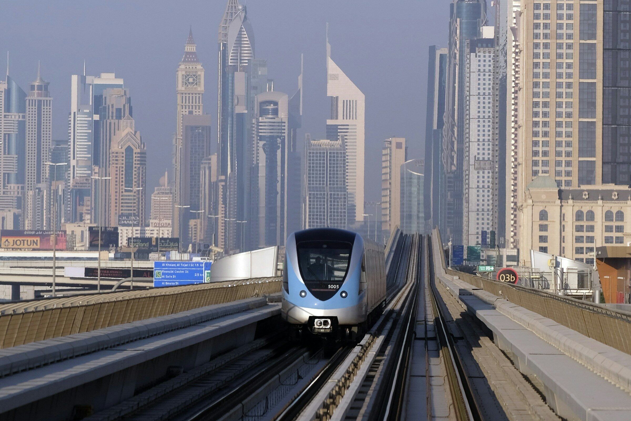 A Dubai Metro train passing tall towers