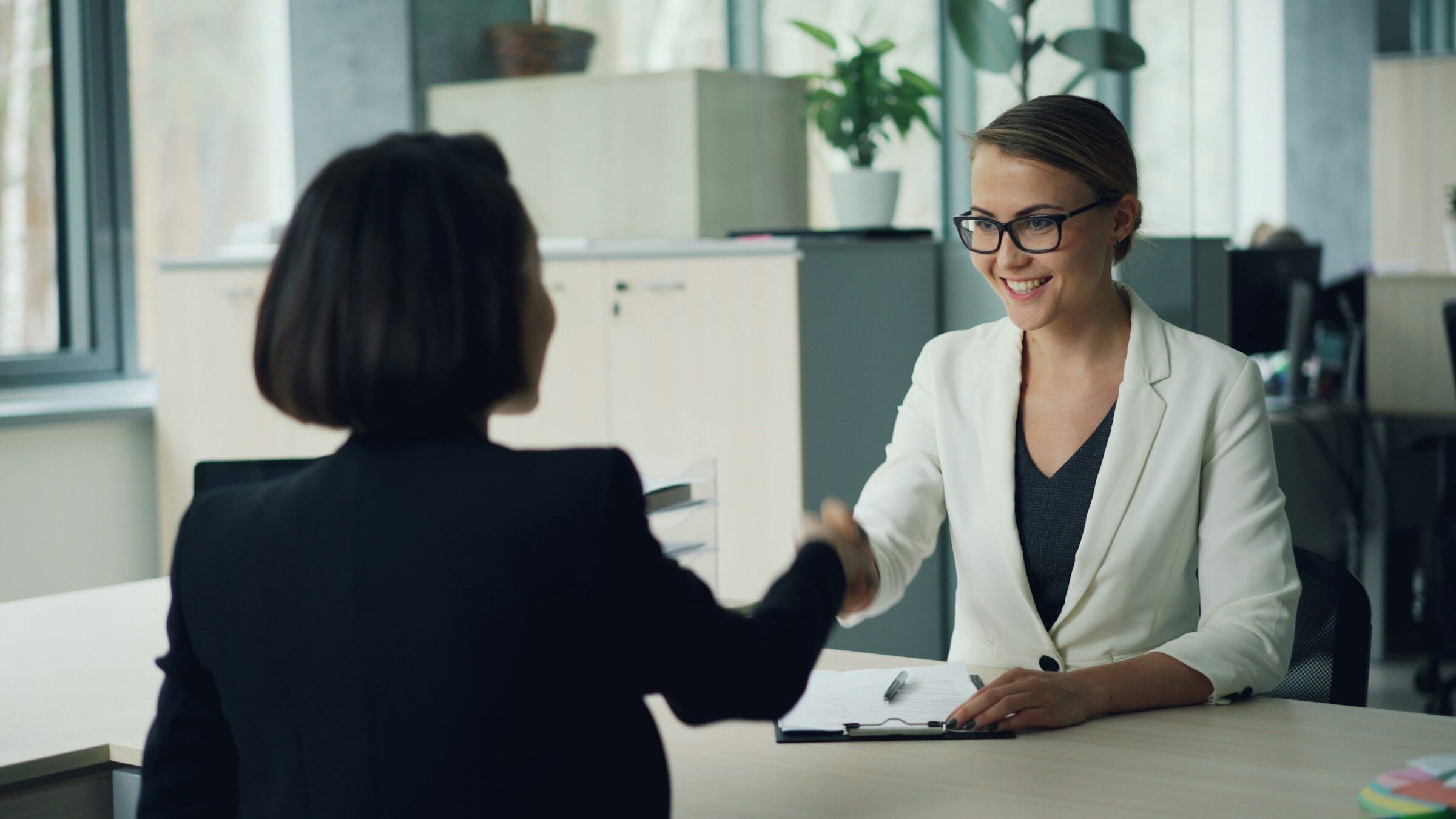 A handshake across a desk as an offer is accepted