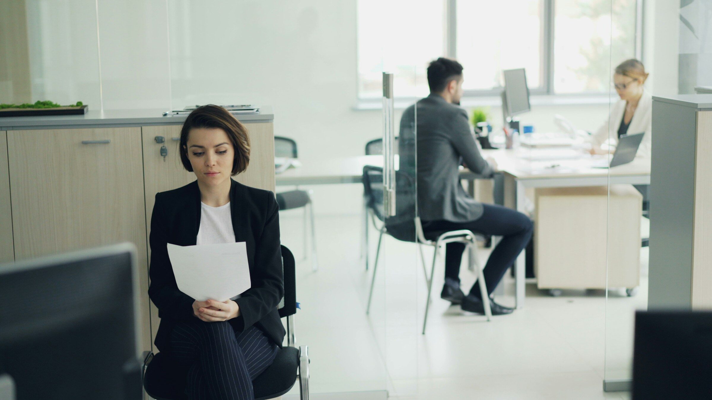 Someone holding a stack of printed forms in an office