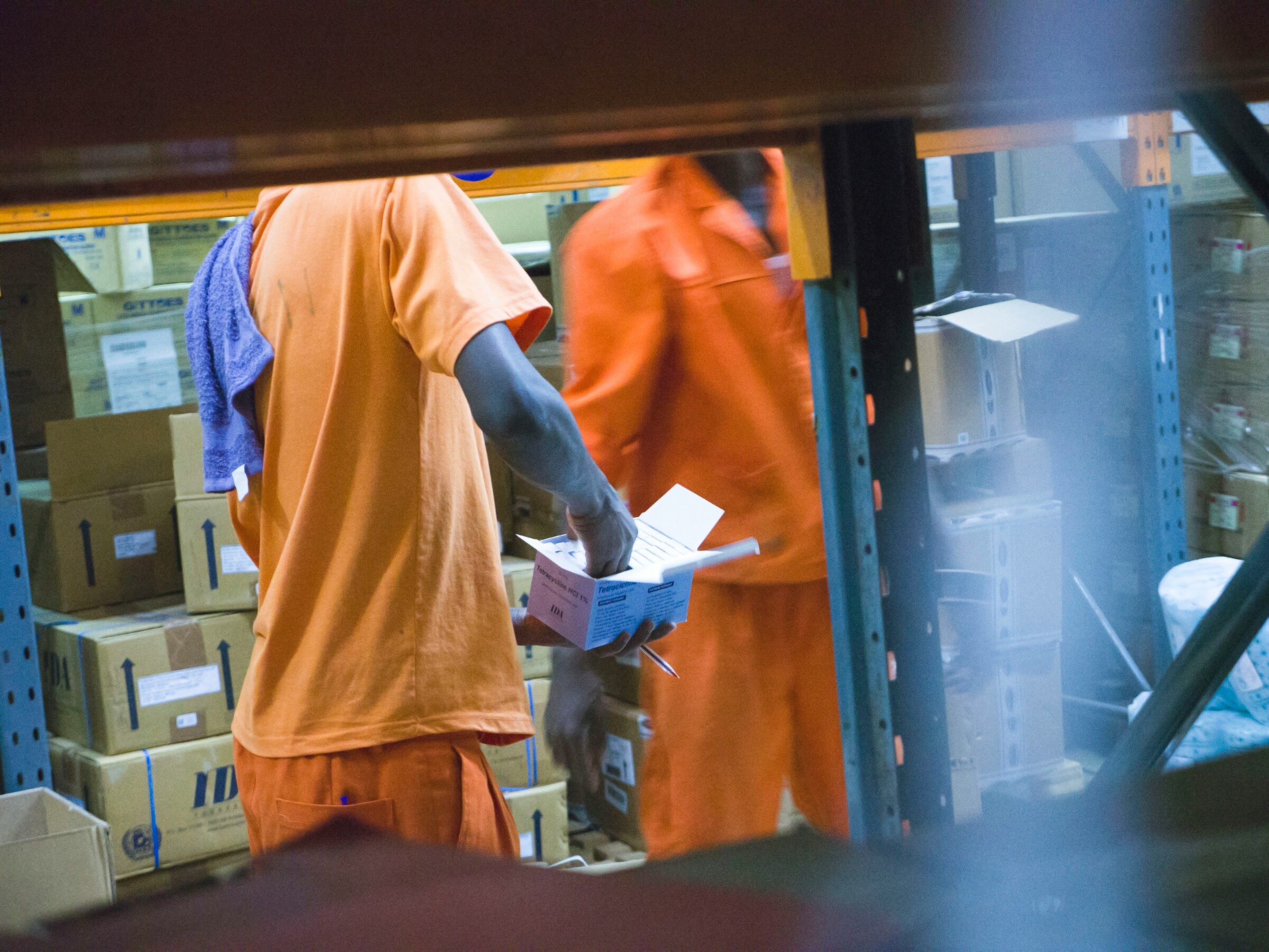 Two warehouse staff checking a printed list against stock