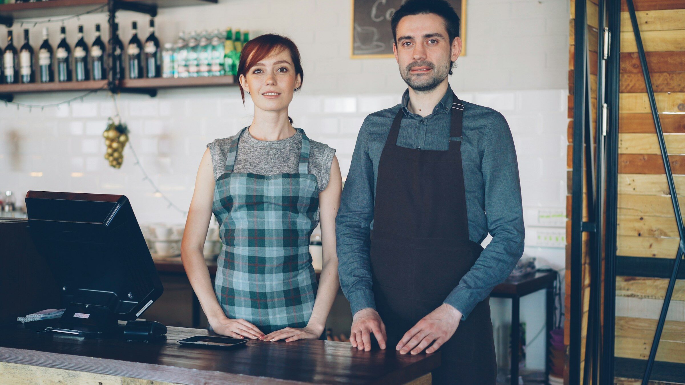 Two staff working behind the counter of a small business