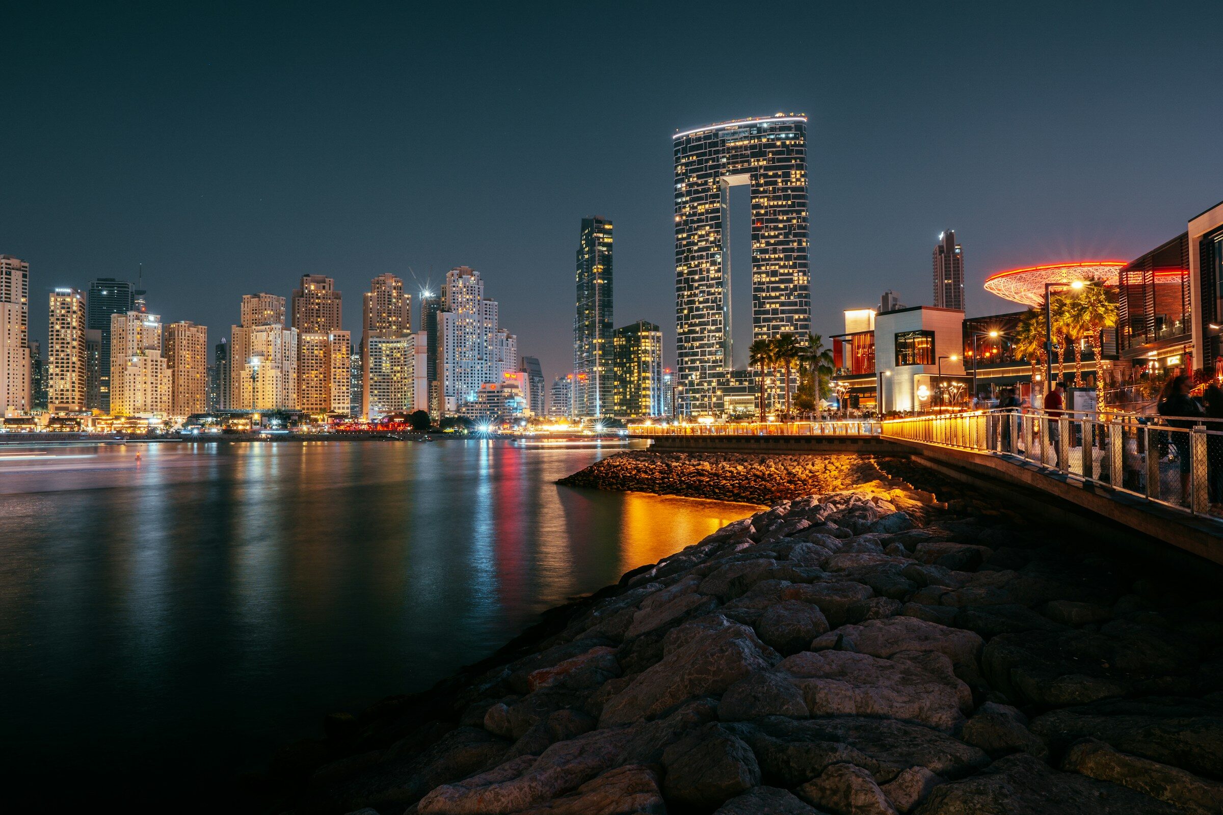 A bridge over the water with the Dubai skyline behind