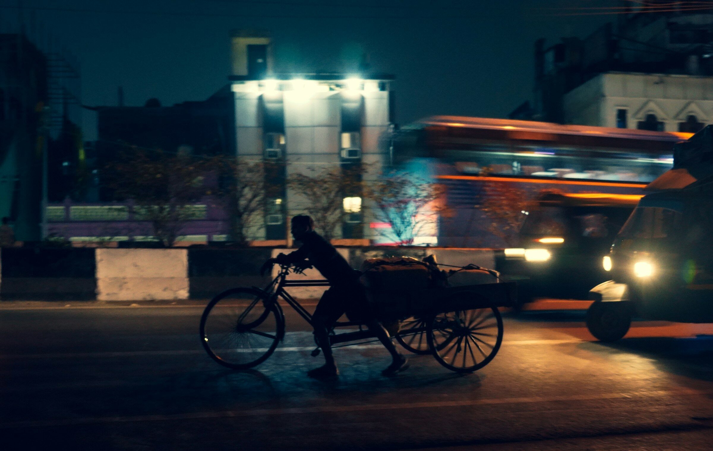 A person riding a bike beside a bus in traffic