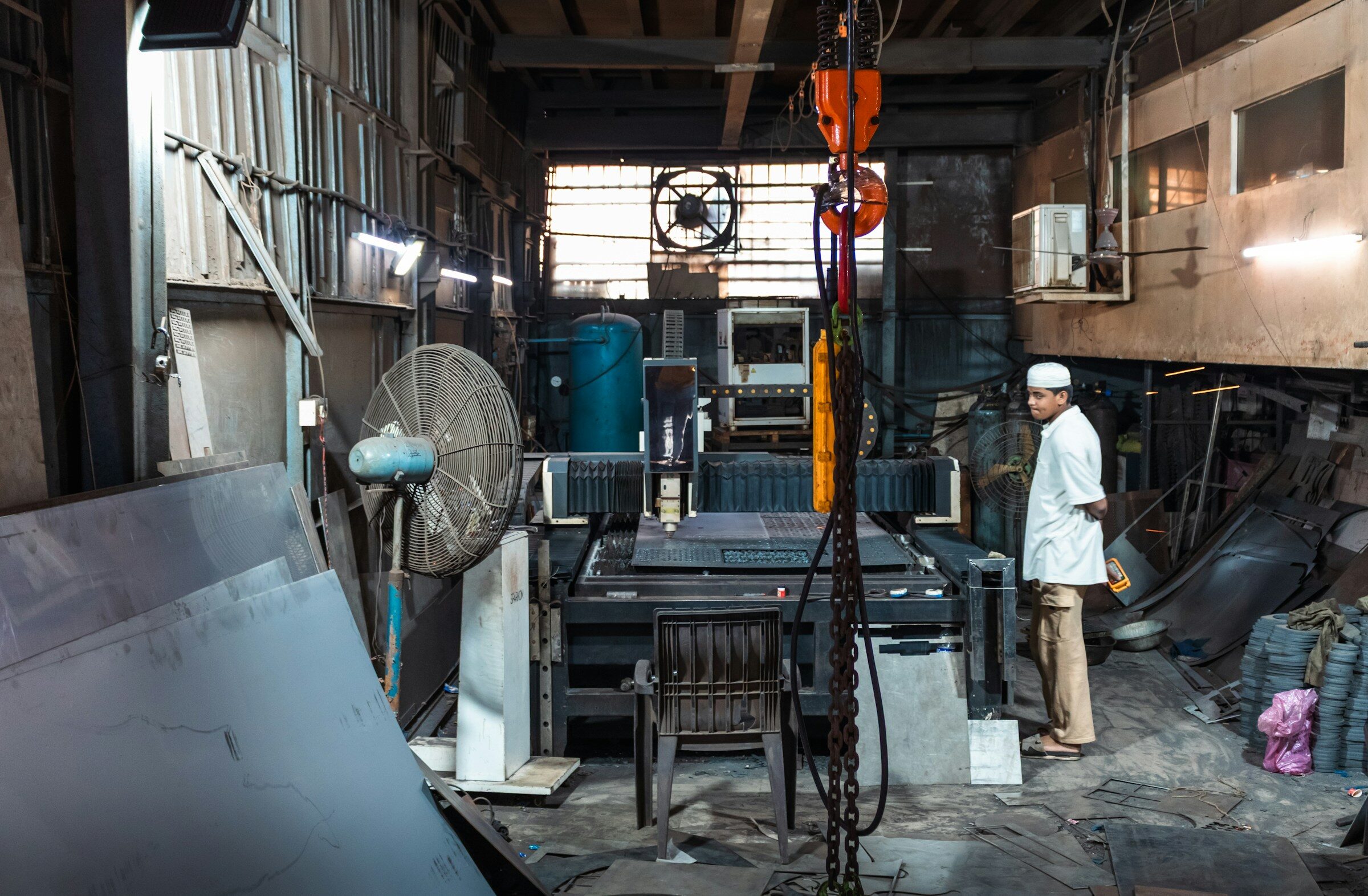 A man in a cluttered industrial workshop