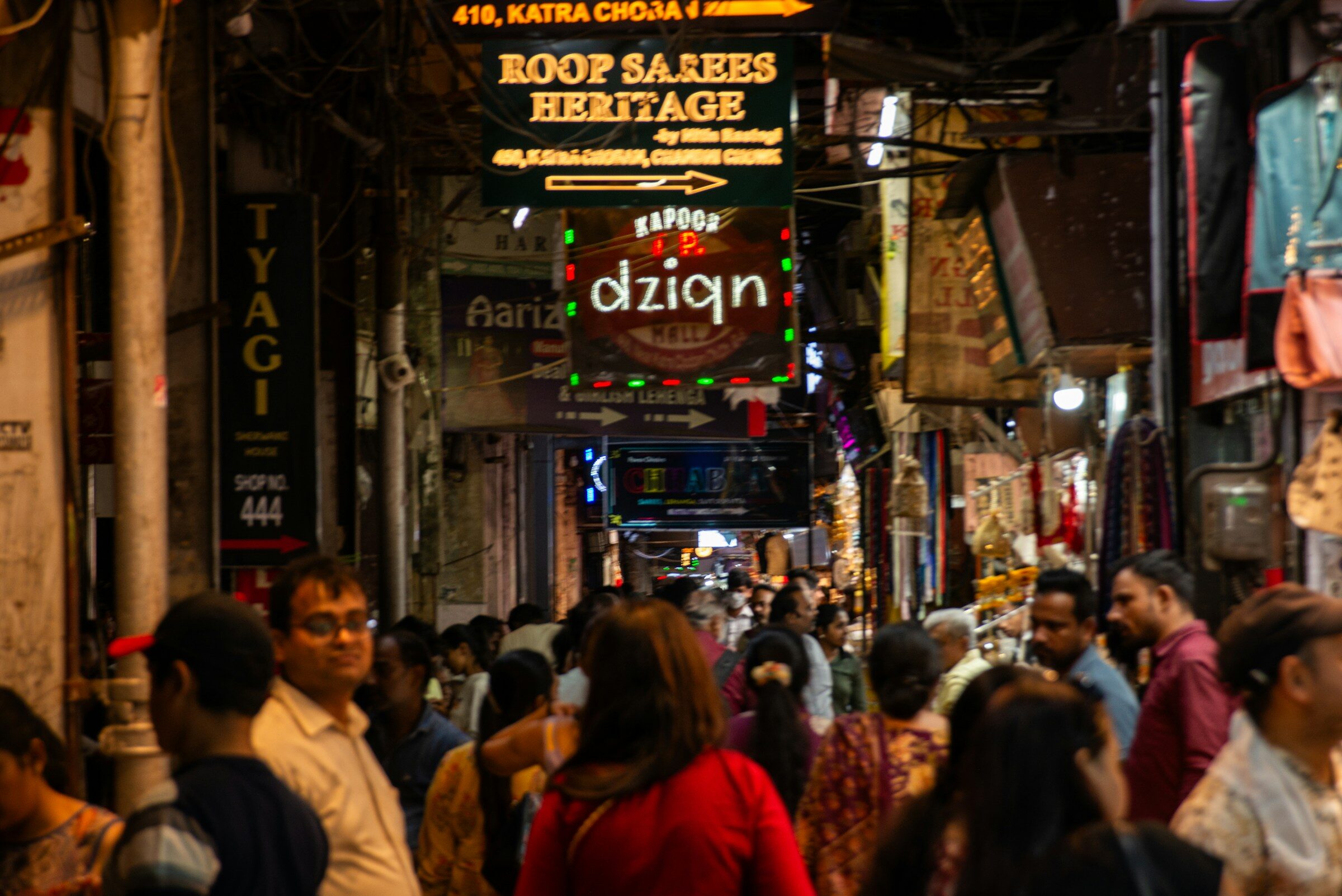 A crowded street market with illuminated signs at night