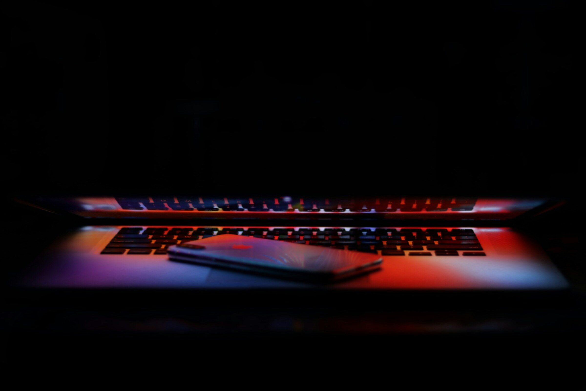 A phone resting on a laptop keyboard