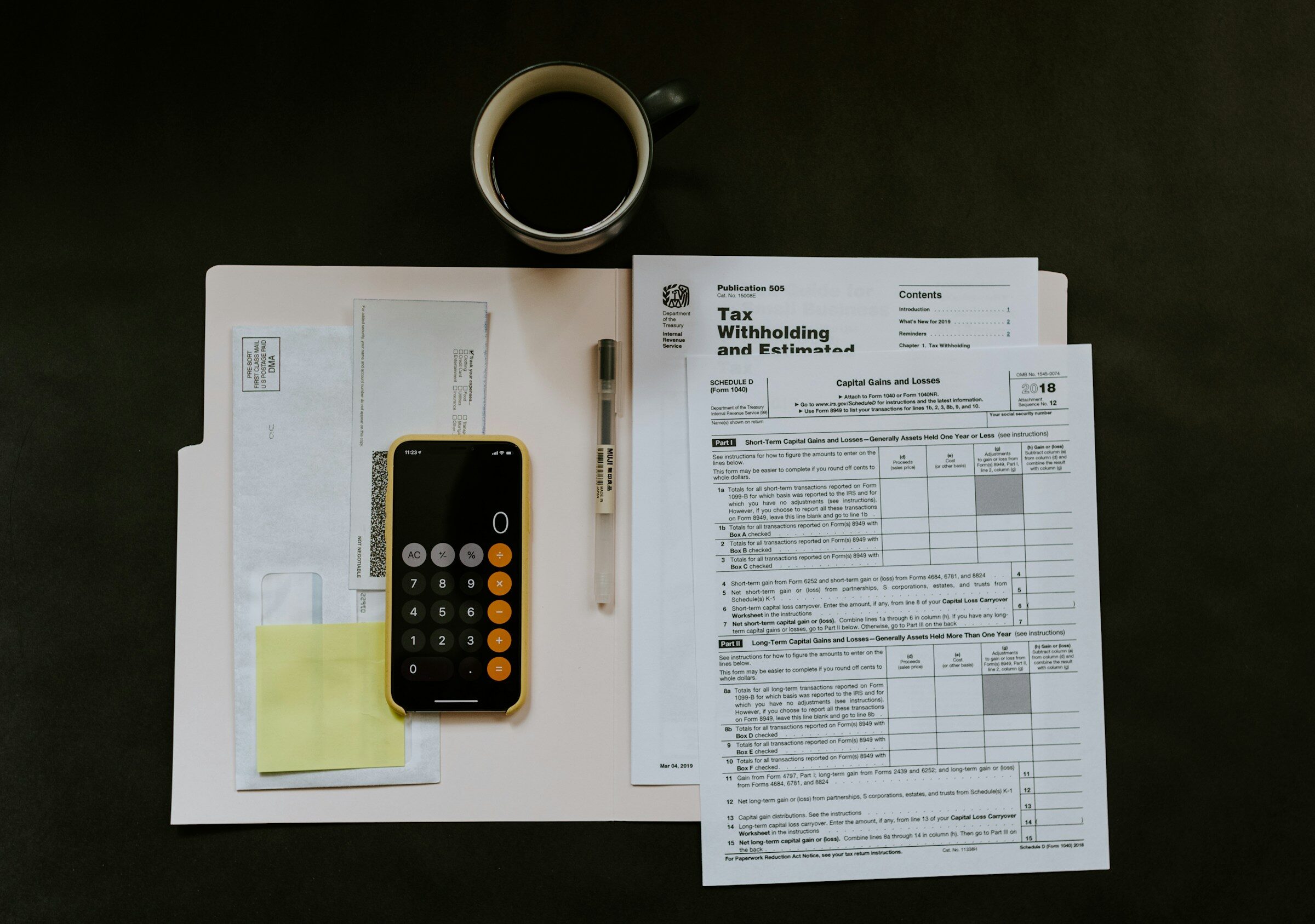 A phone and pen beside a certificate on a folder