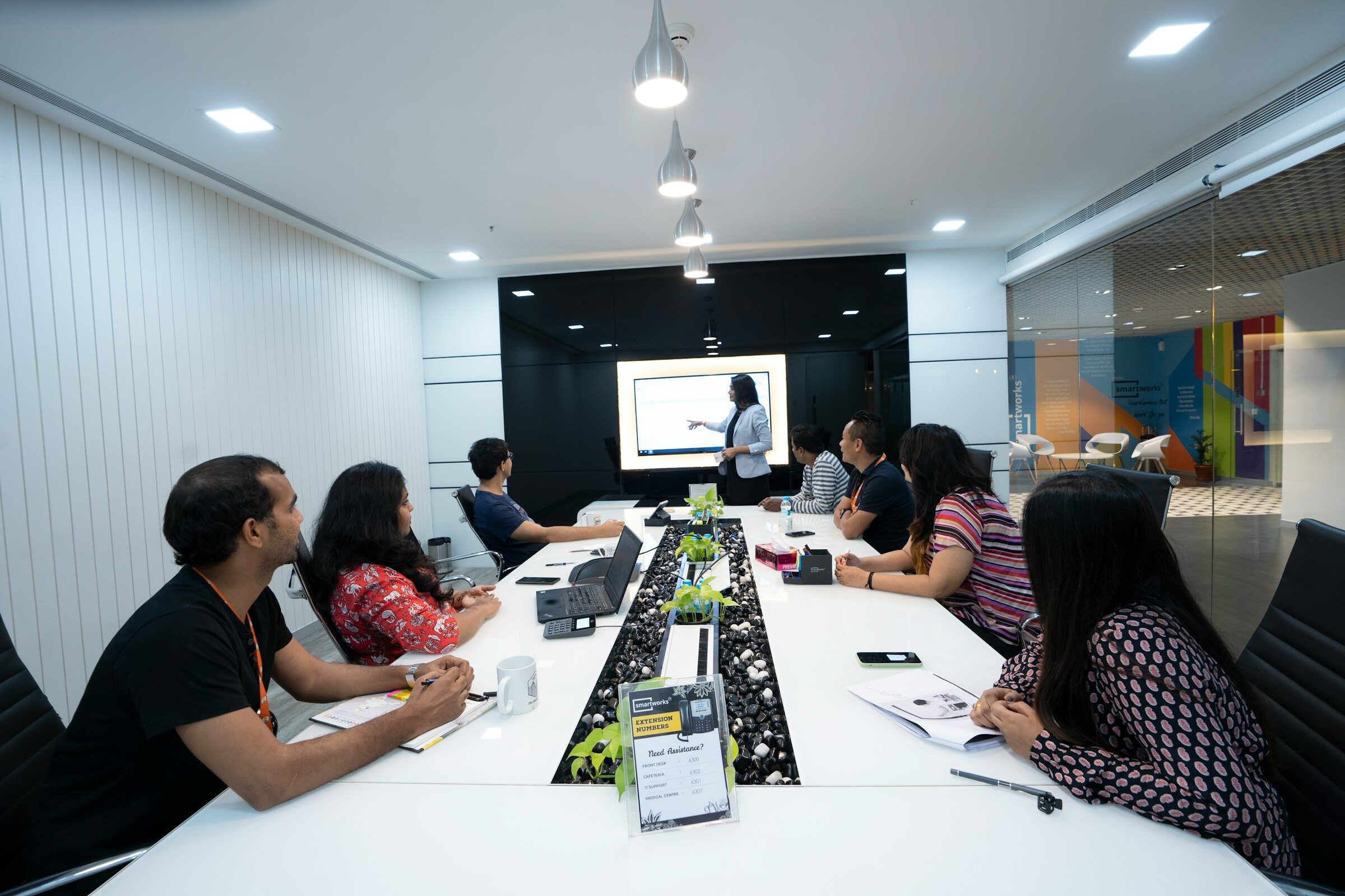 A team seated at a table listening to a colleague