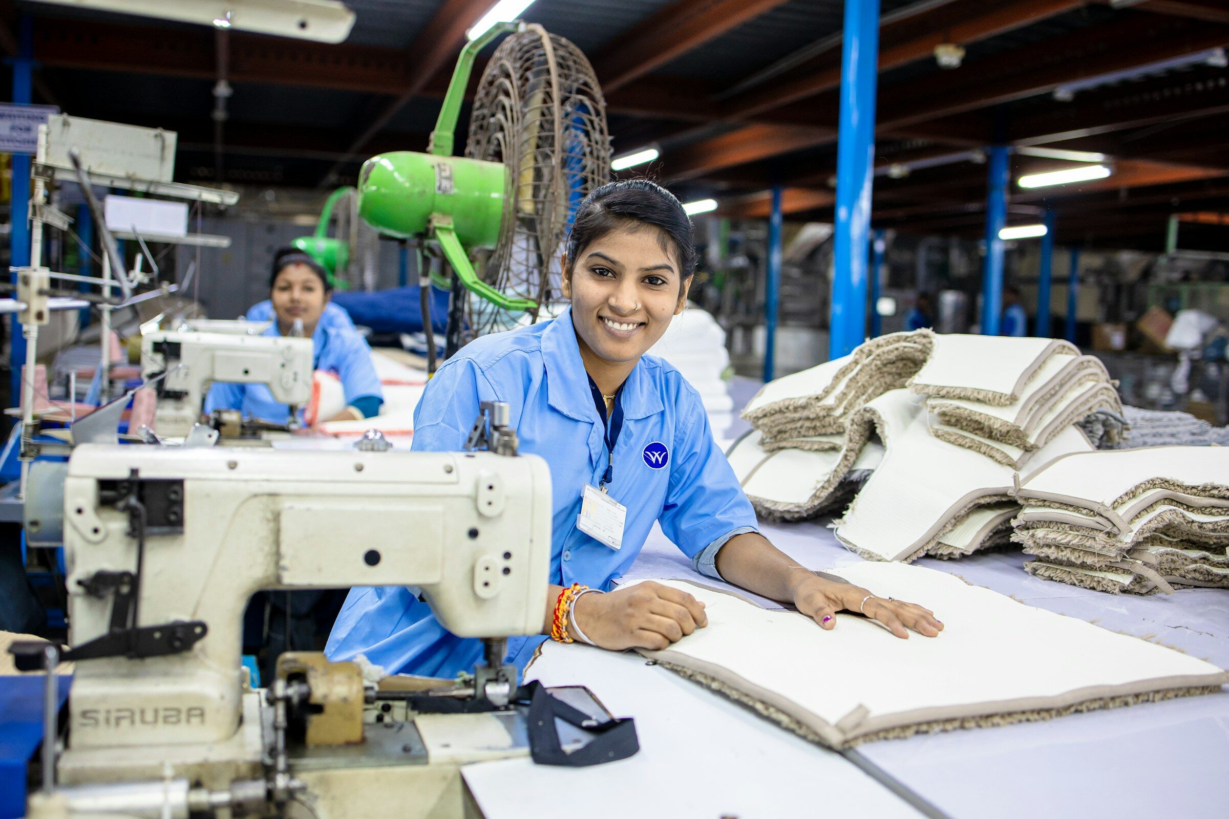 Factory workers sewing fabric together
