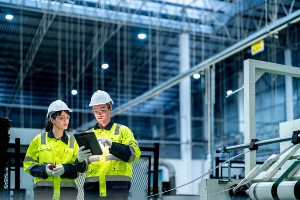 Manufacturing engineers reviewing production status on a tablet