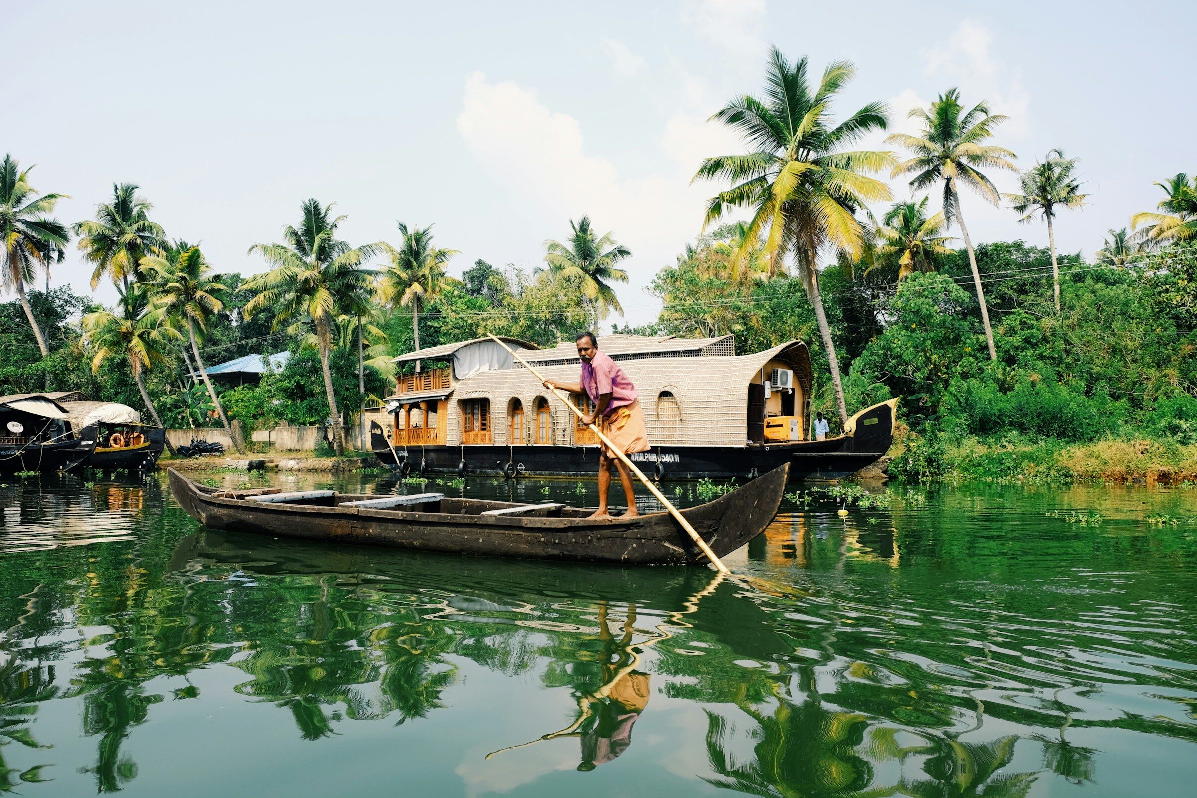 A man on a small boat on Kerala waters