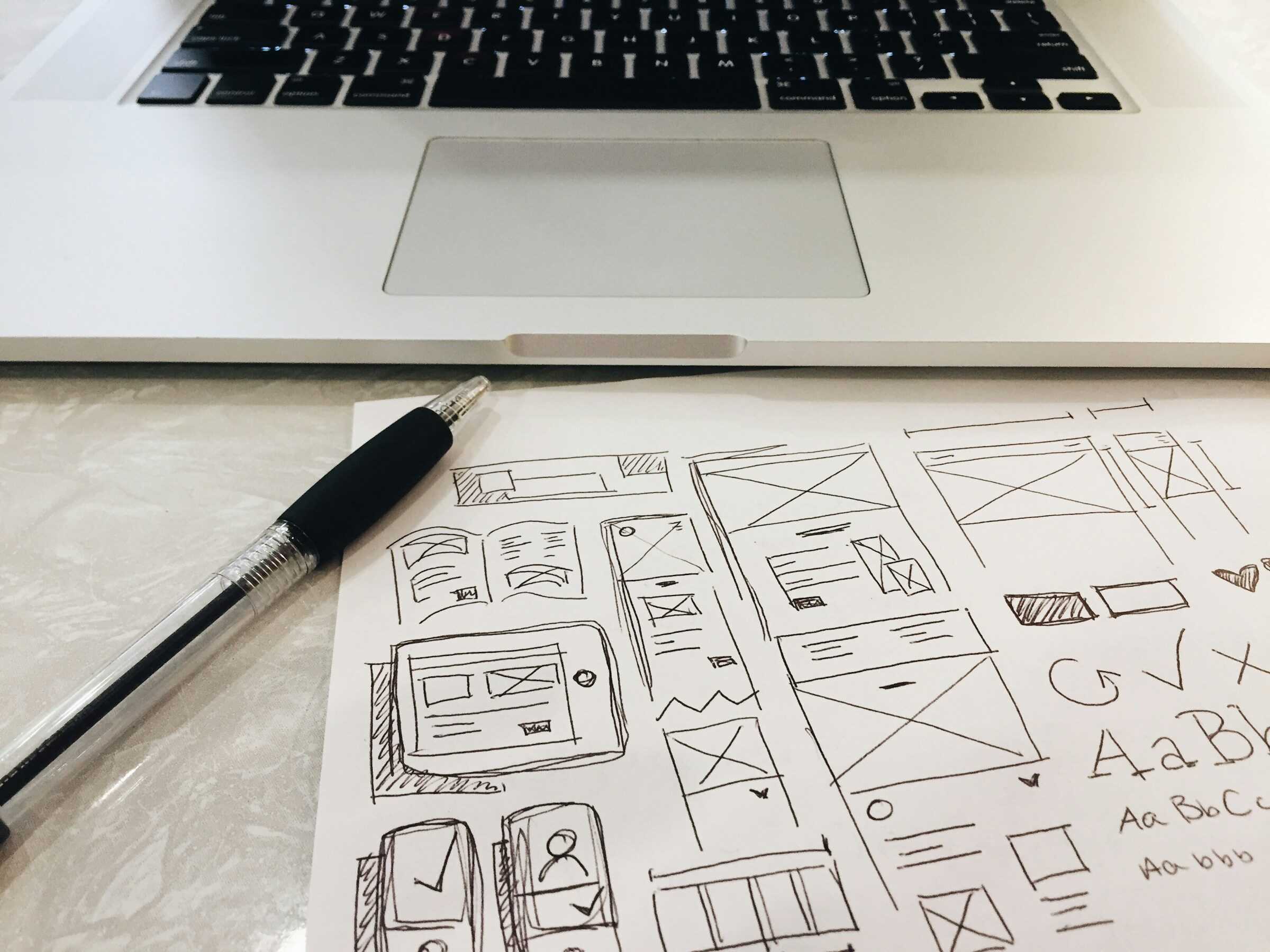 A pen on the desk beside a laptop, working through a quote