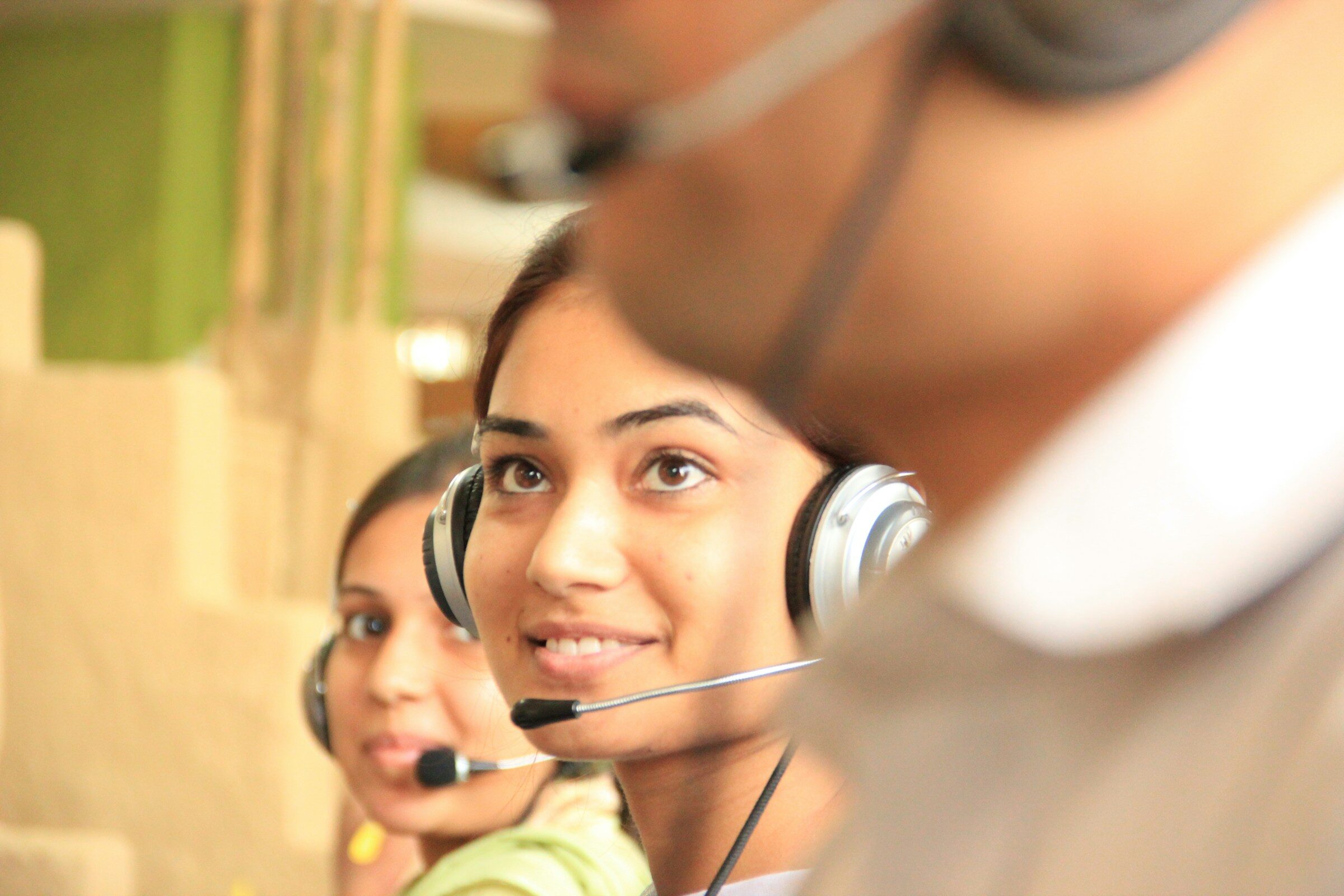 Two people on headsets at their desks