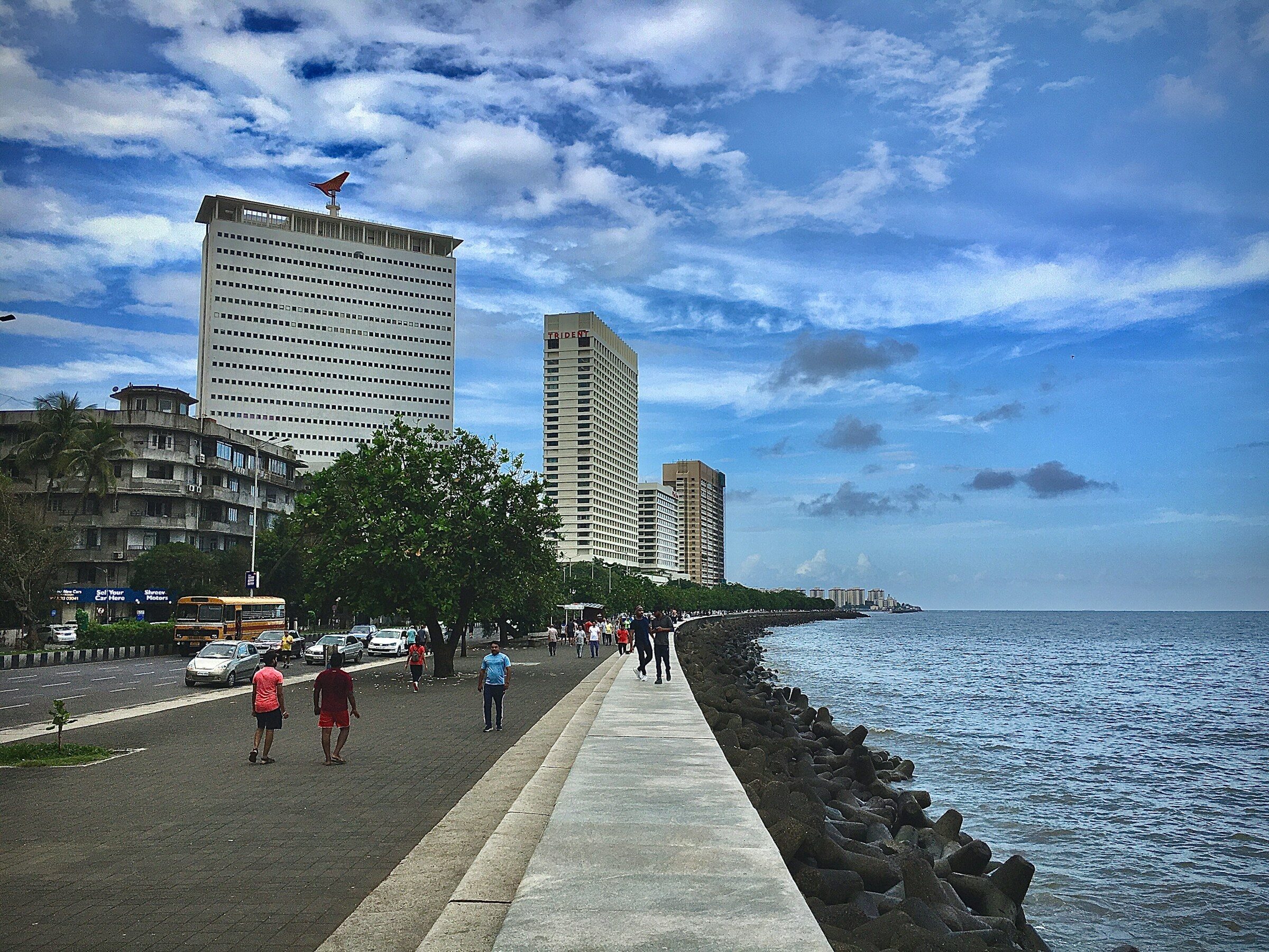 People walking along the Marine Drive promenade with towers behind