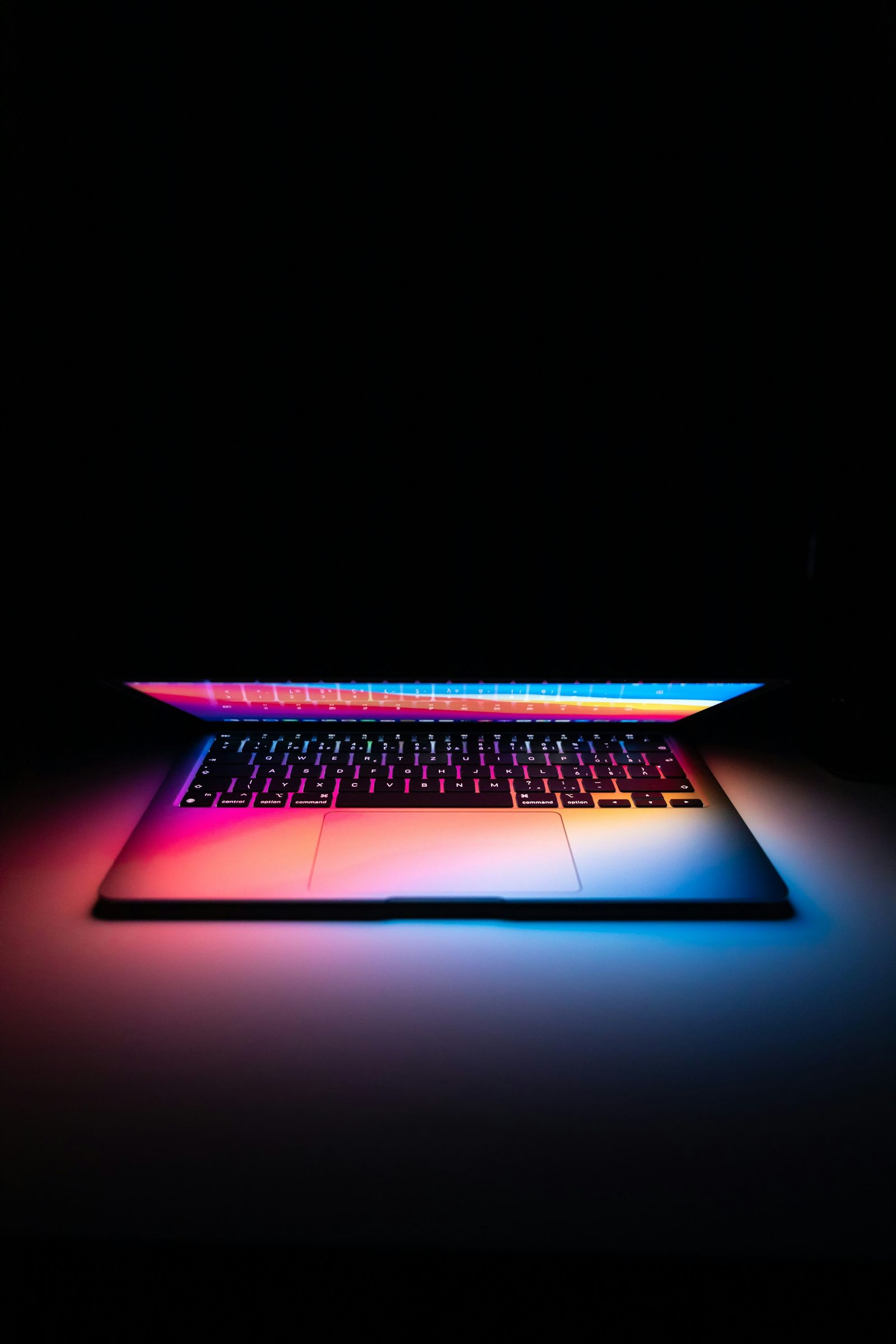 A laptop switched on in dim light