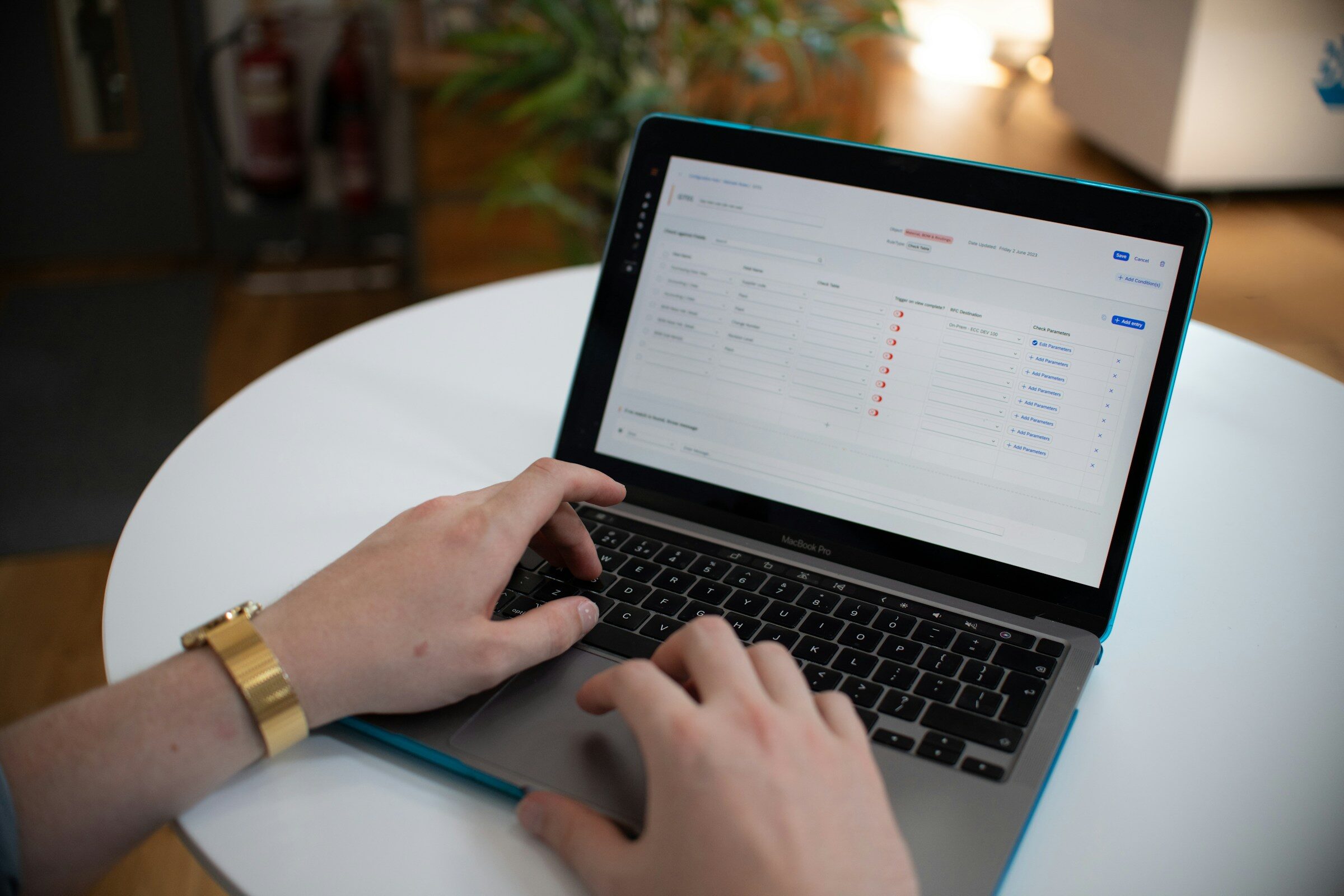 Hands typing with a spreadsheet of figures on screen