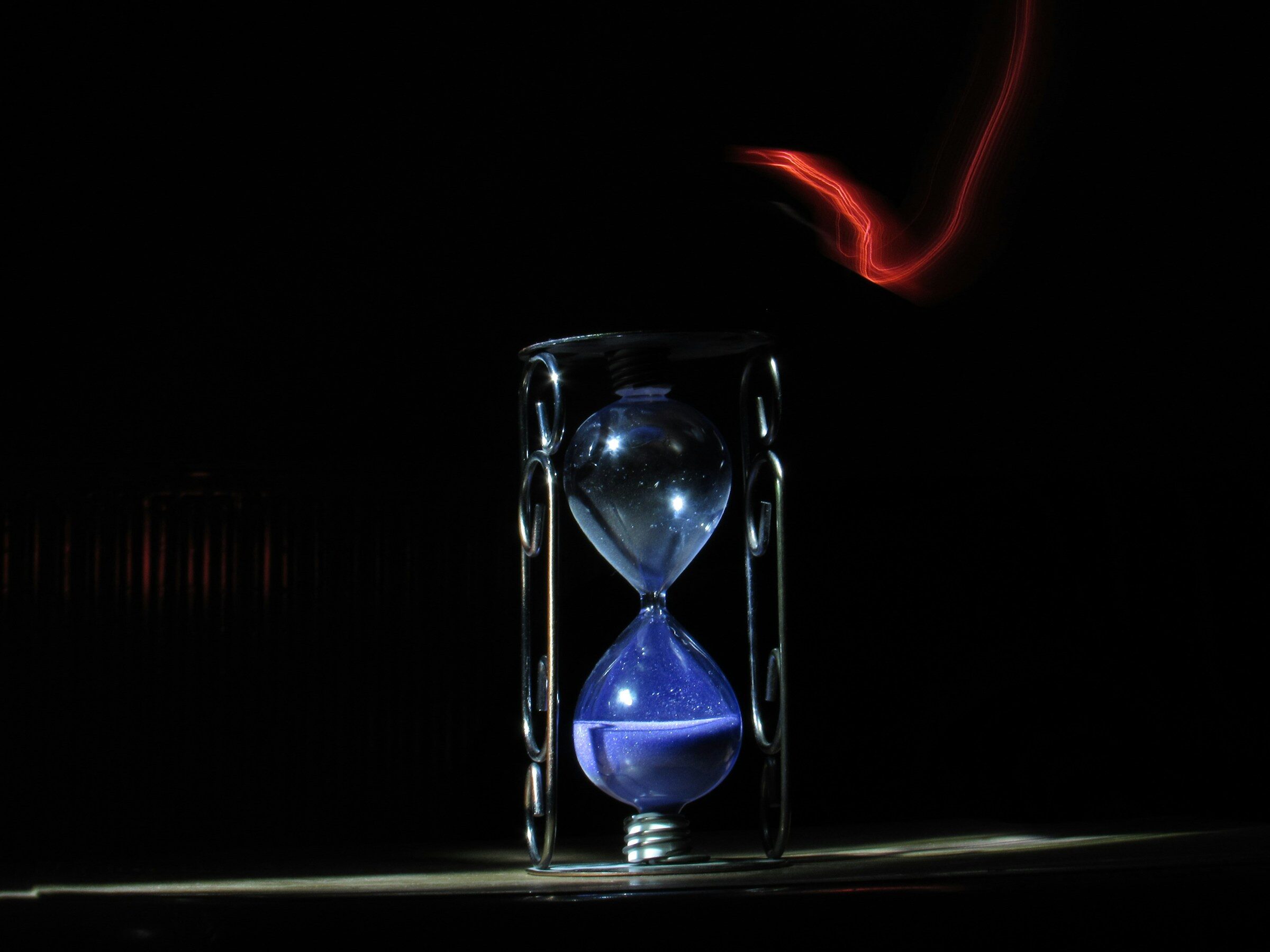 An hourglass on a table in low light