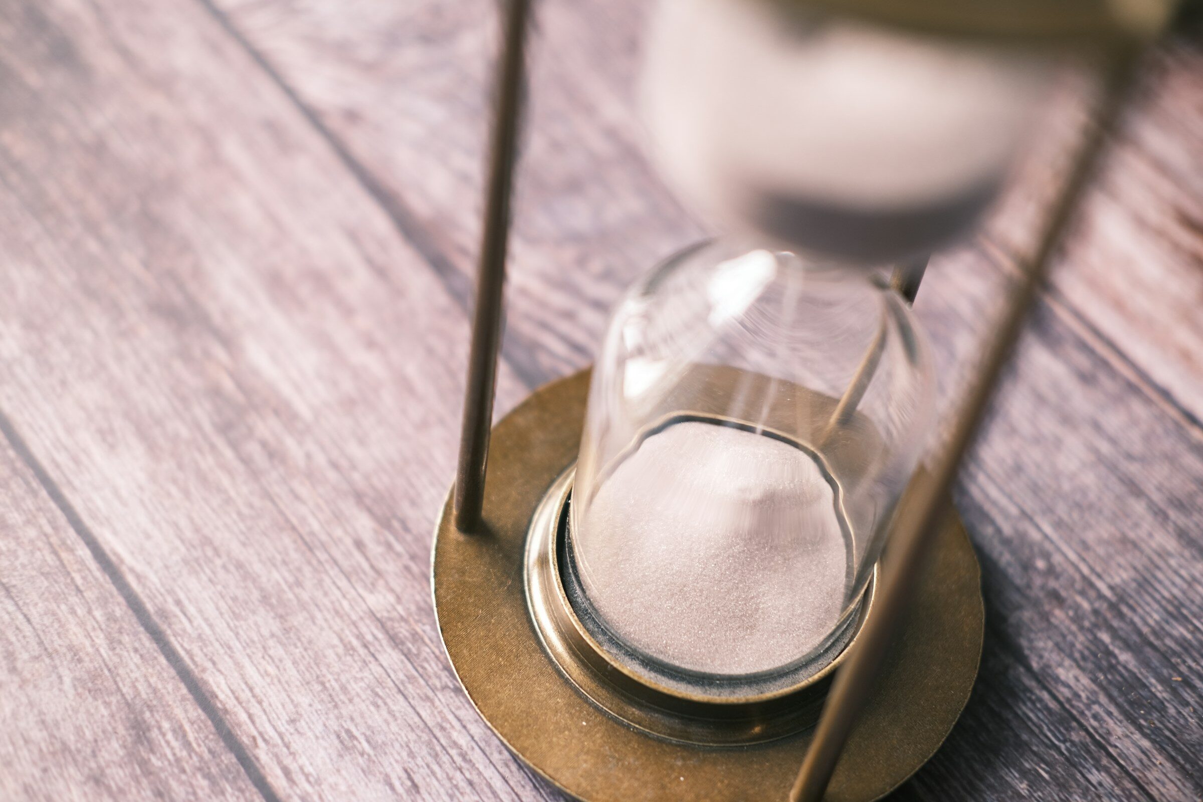 An hourglass standing on a wooden table