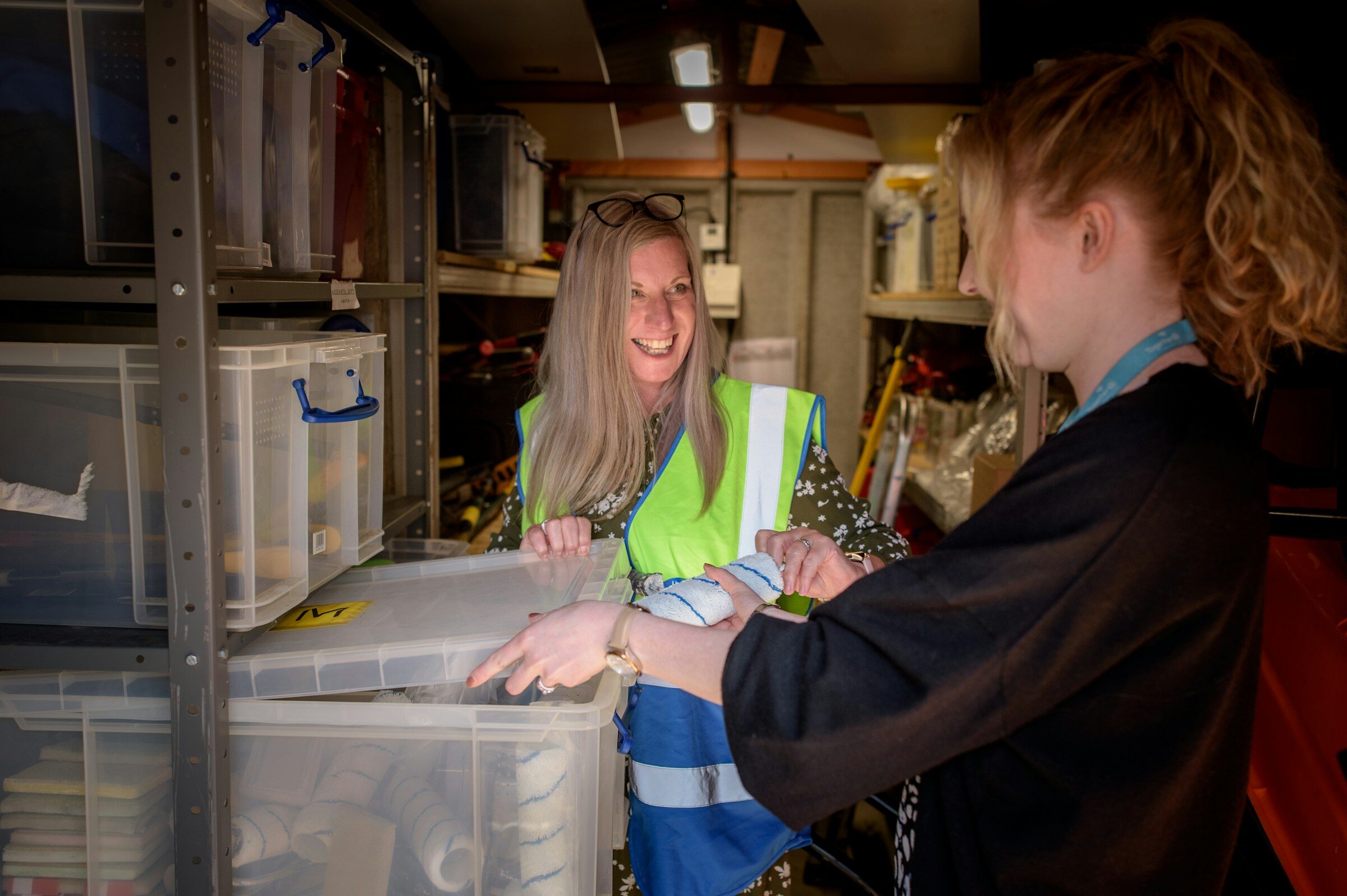 Two colleagues checking figures in a paper file