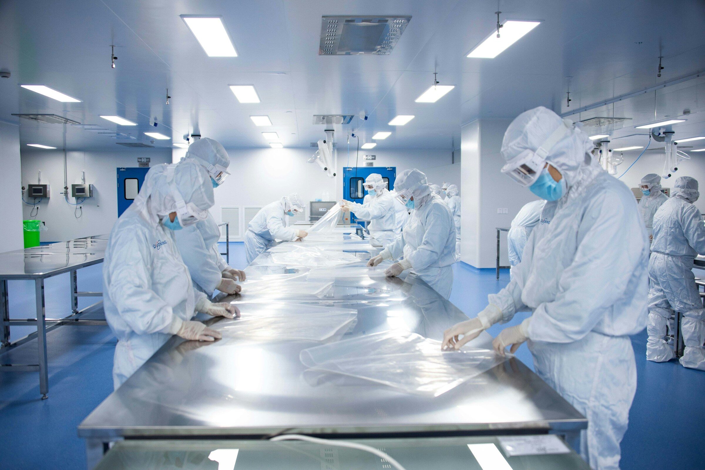 Production staff in lab coats and masks on a food manufacturing floor