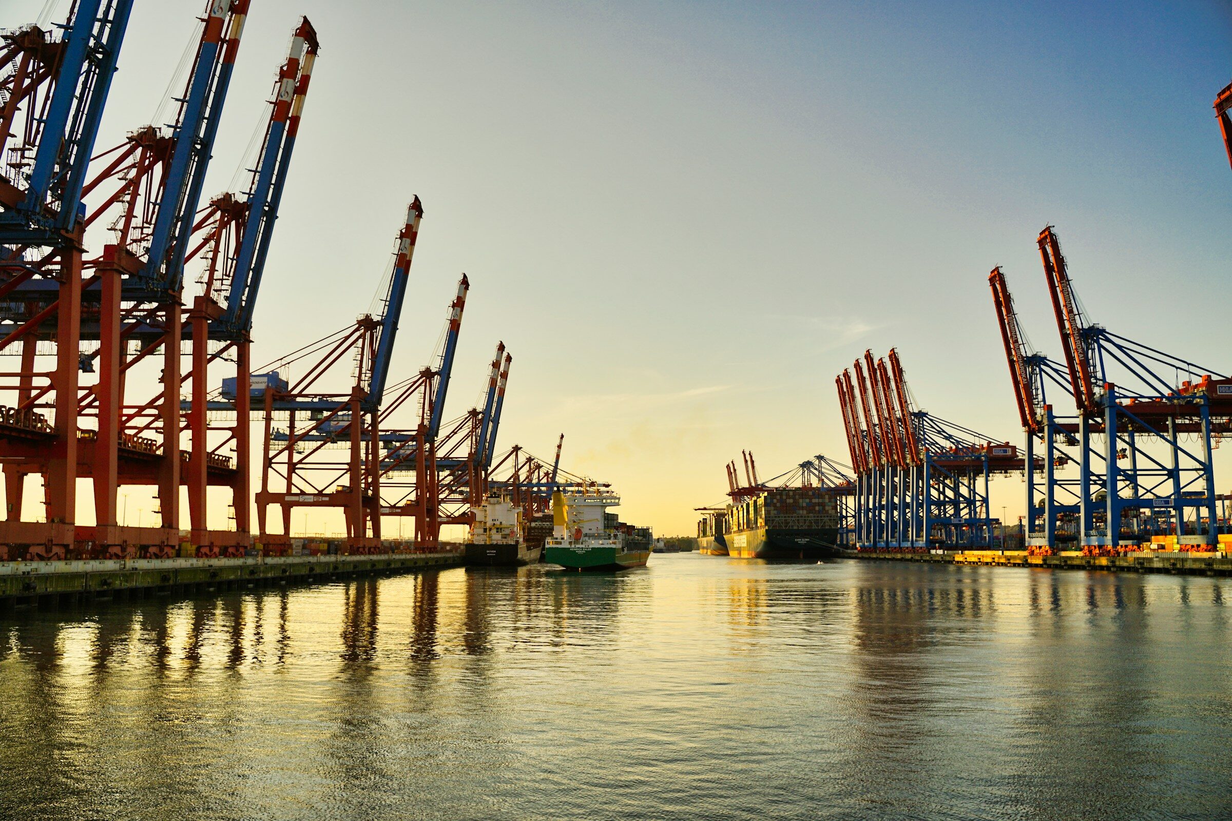 Cranes along a working harbour at dusk