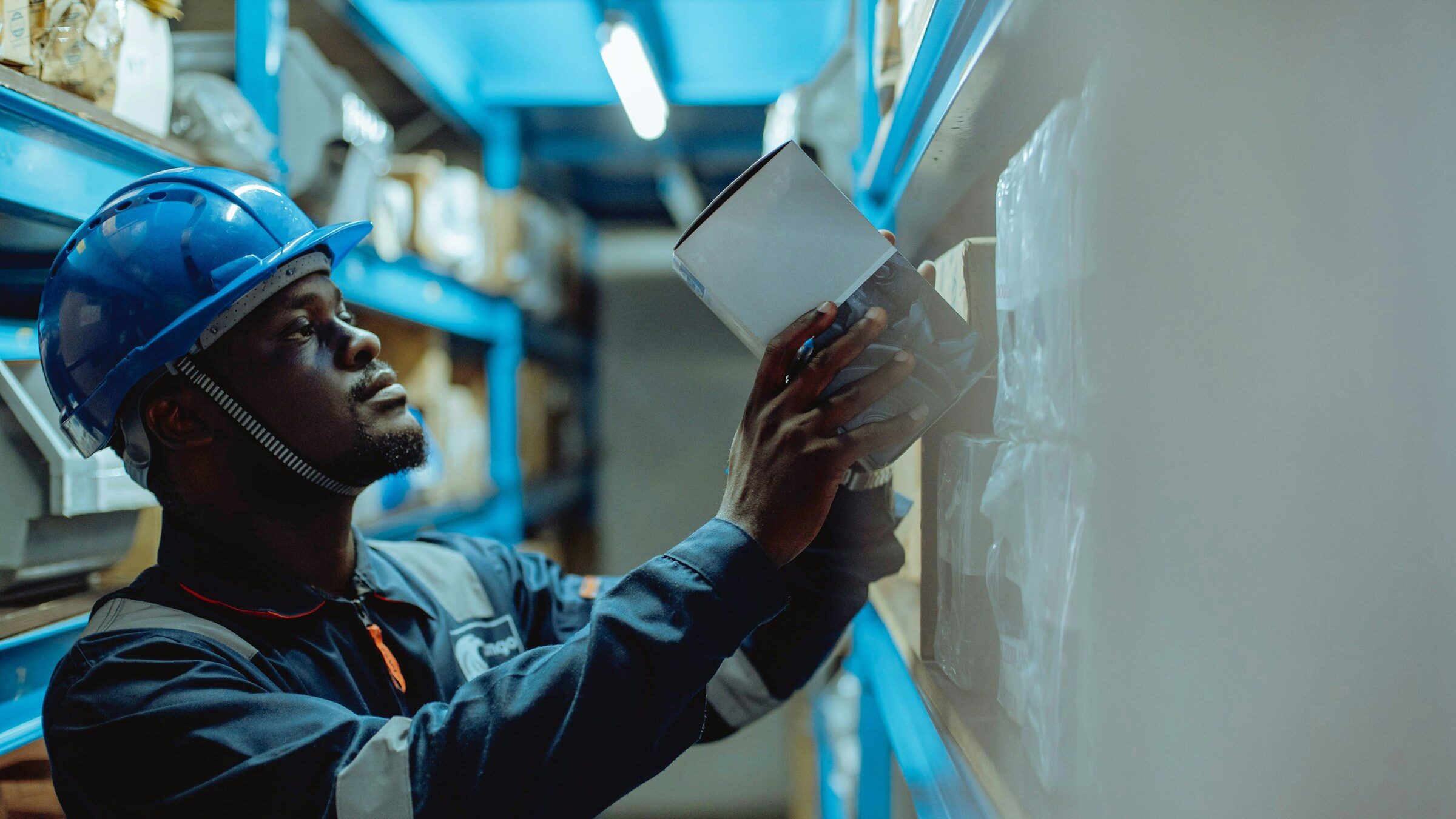 Worker in a hard hat reading a printed job sheet on site