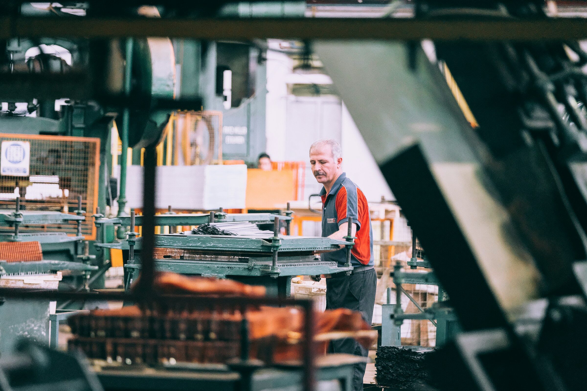 Machine operator working the controls of an industrial machine