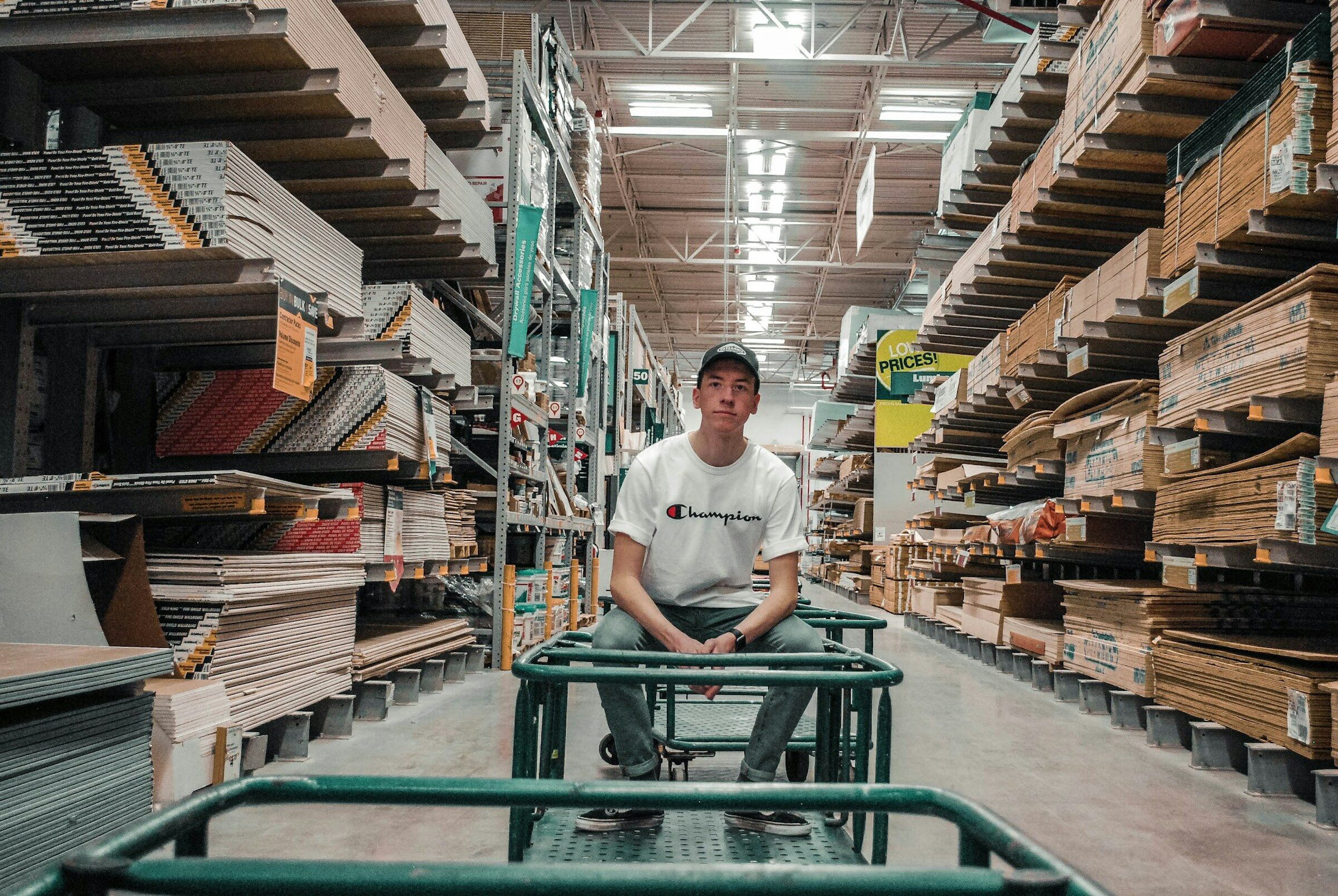 Warehouse operative sitting with a stock trolley