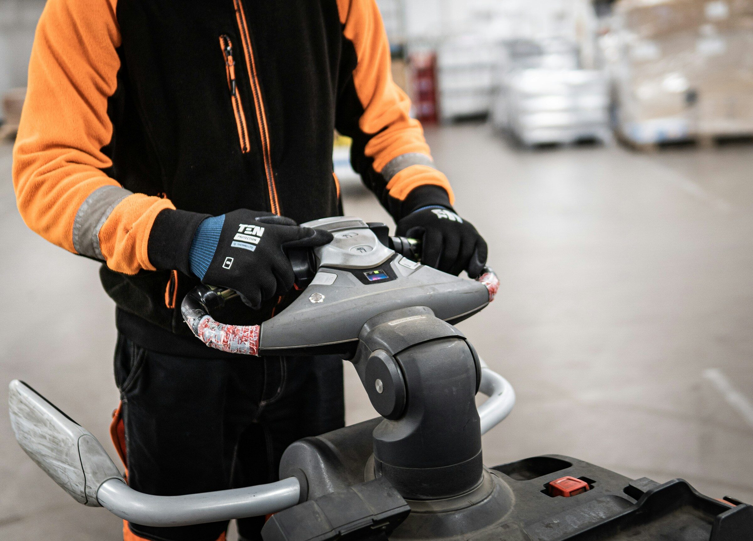 Operative working the controls of a powered pallet truck