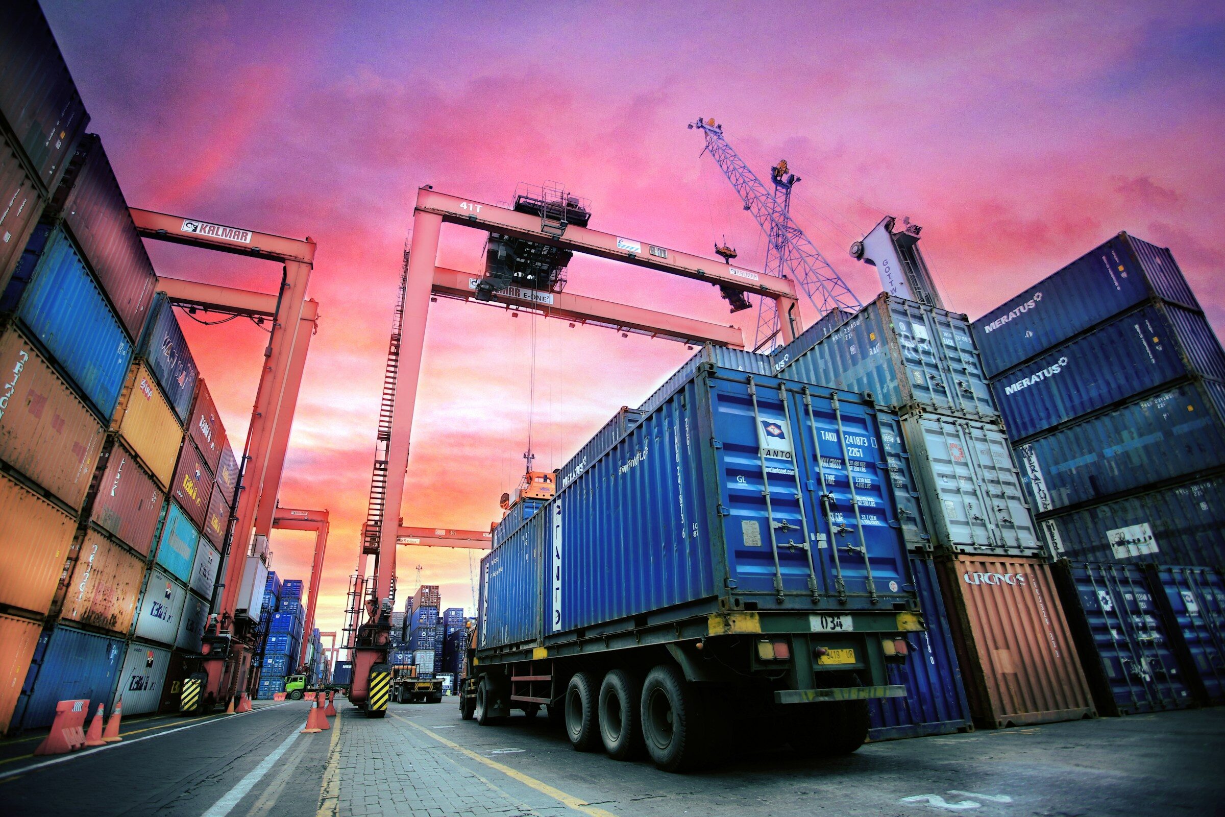 Containers and a lorry at a working port at sunset