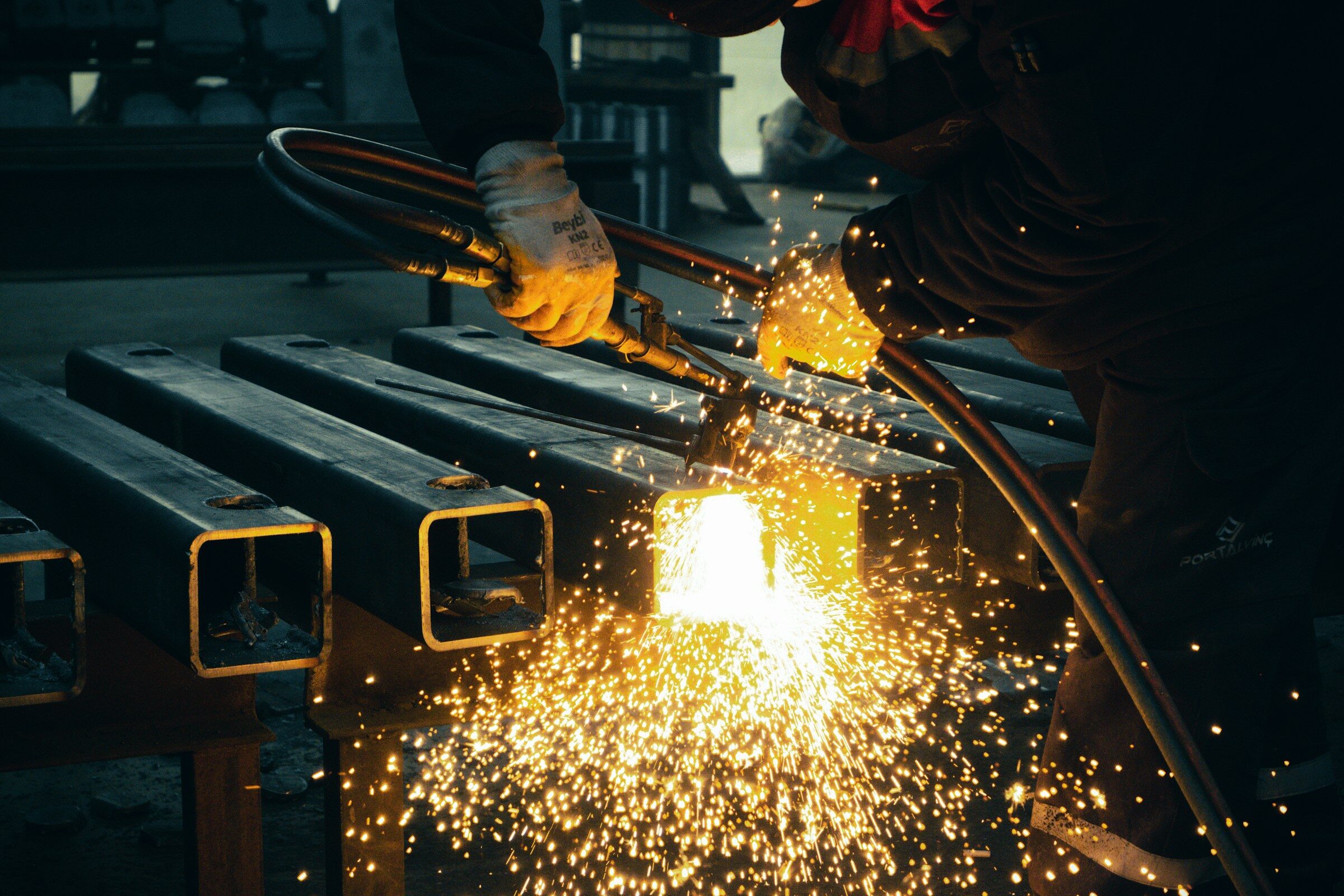 Welder working steel inside a fabrication shop