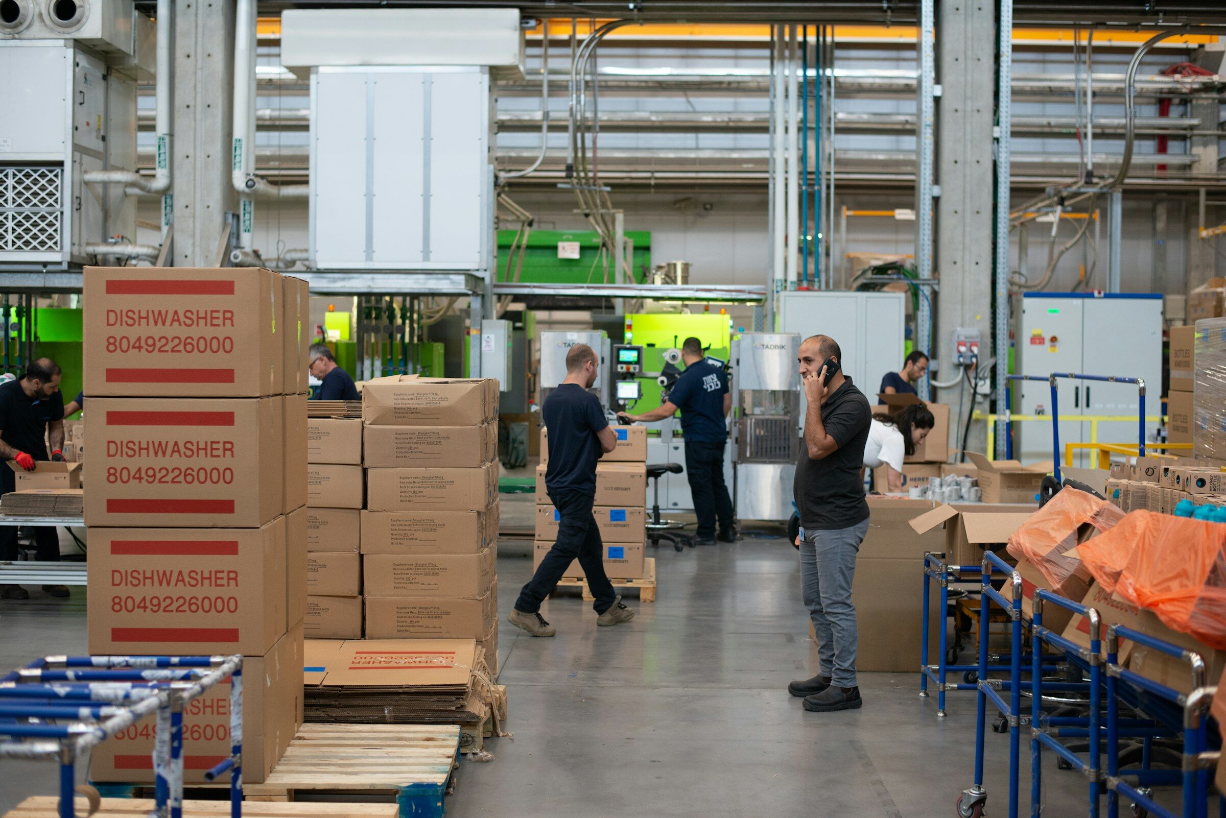 Worker standing beside stacked cartons in a stockroom