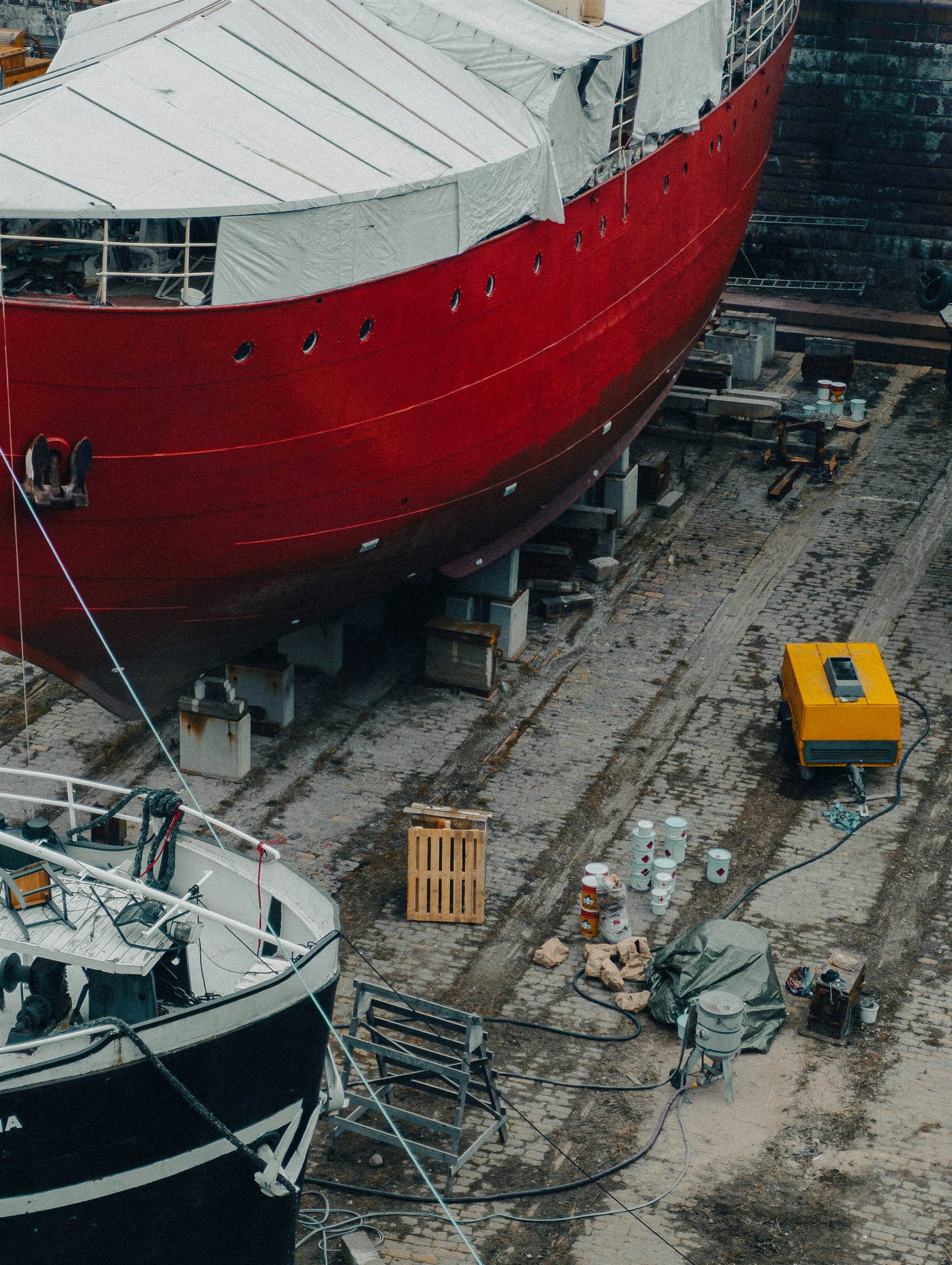 A red-hulled ship standing in dry dock