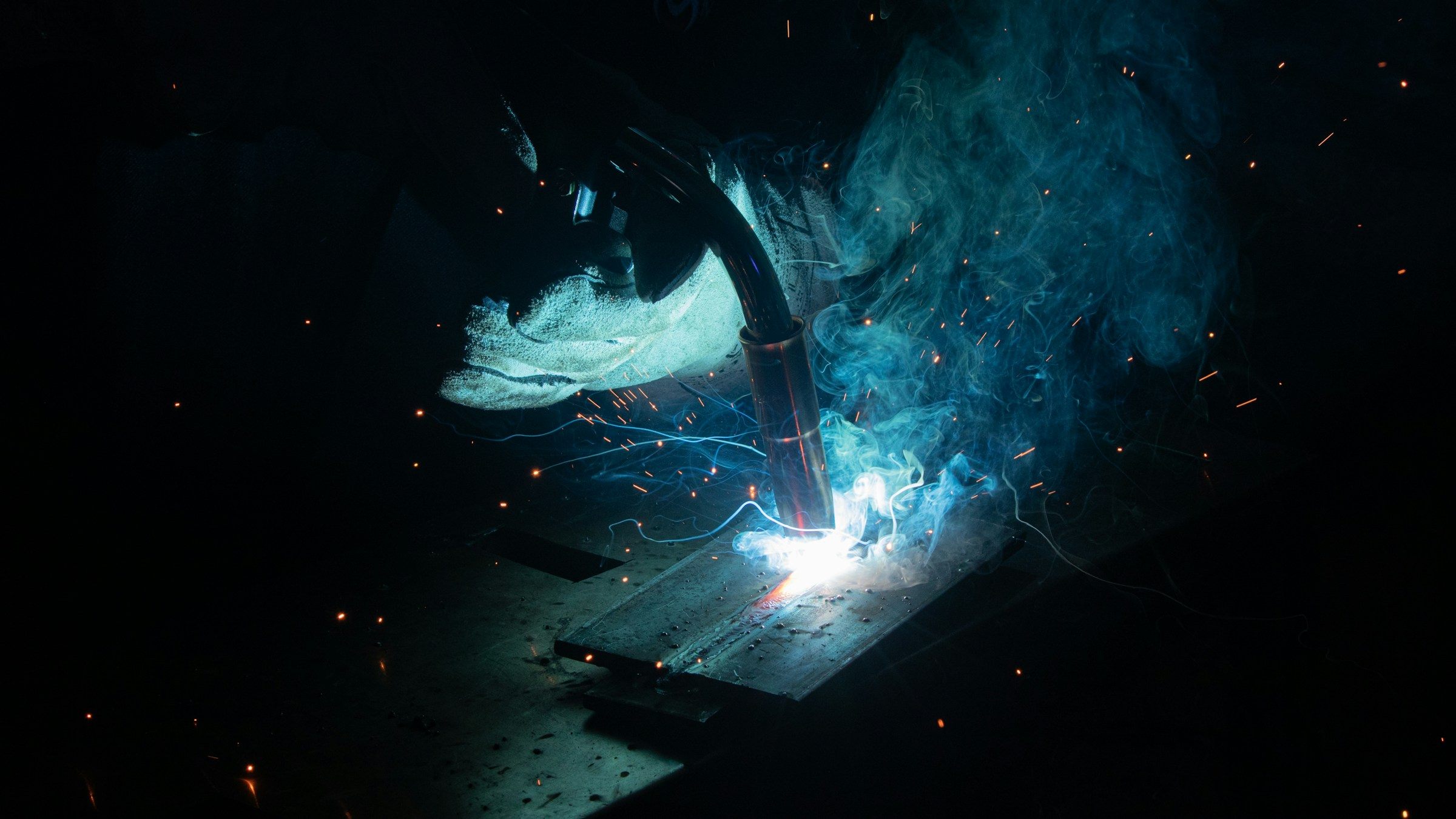 A welding arc with sparks and blue smoke