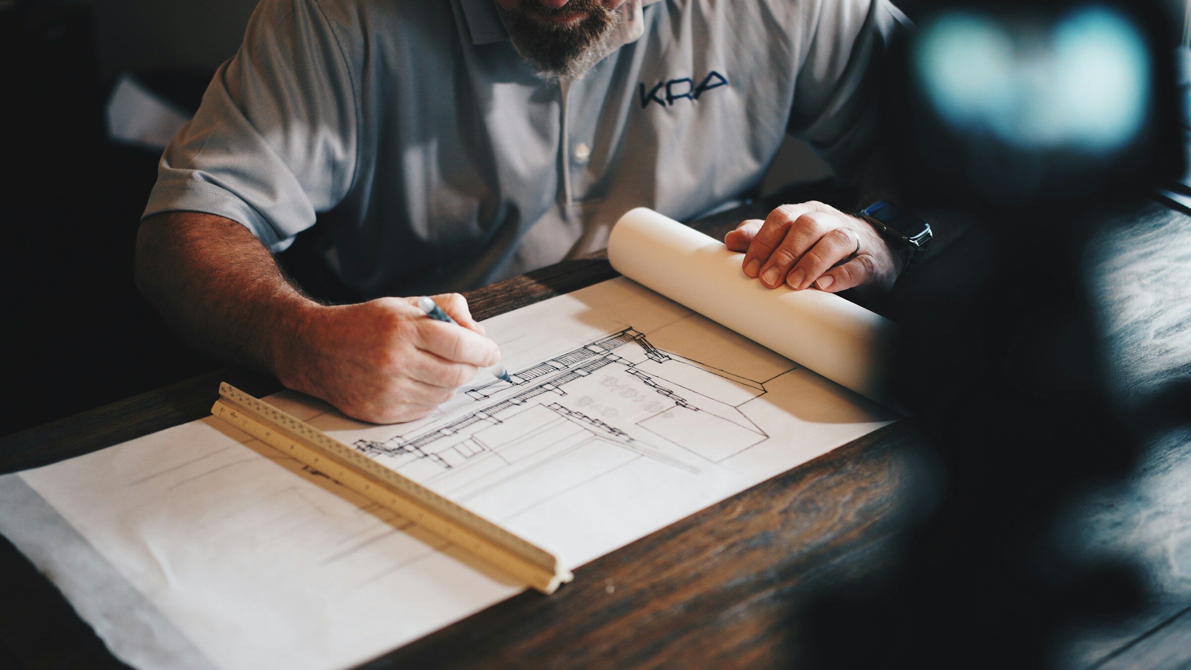 An architect working on a drawing with a pencil and ruler