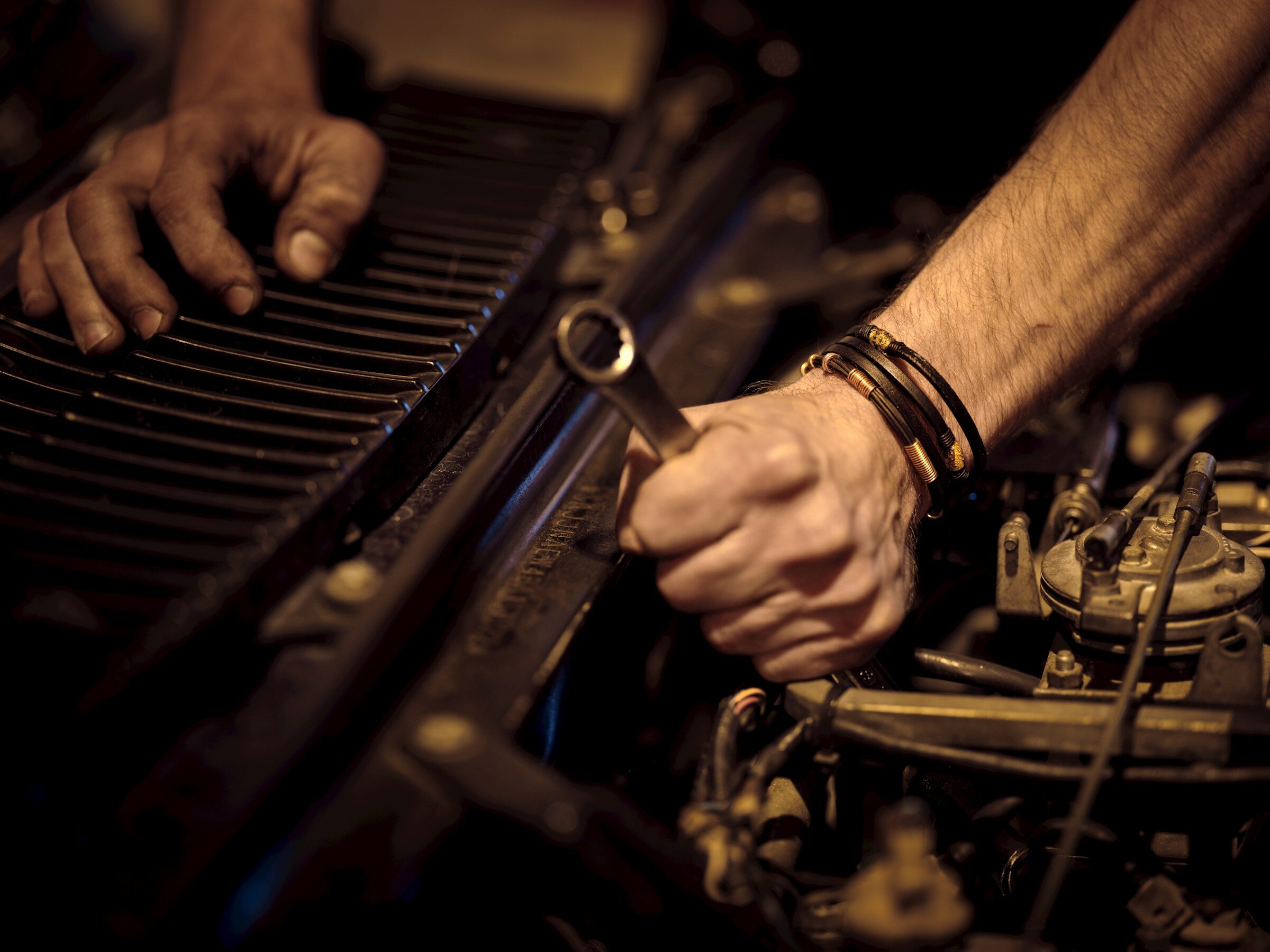Hands working on an engine with a spanner