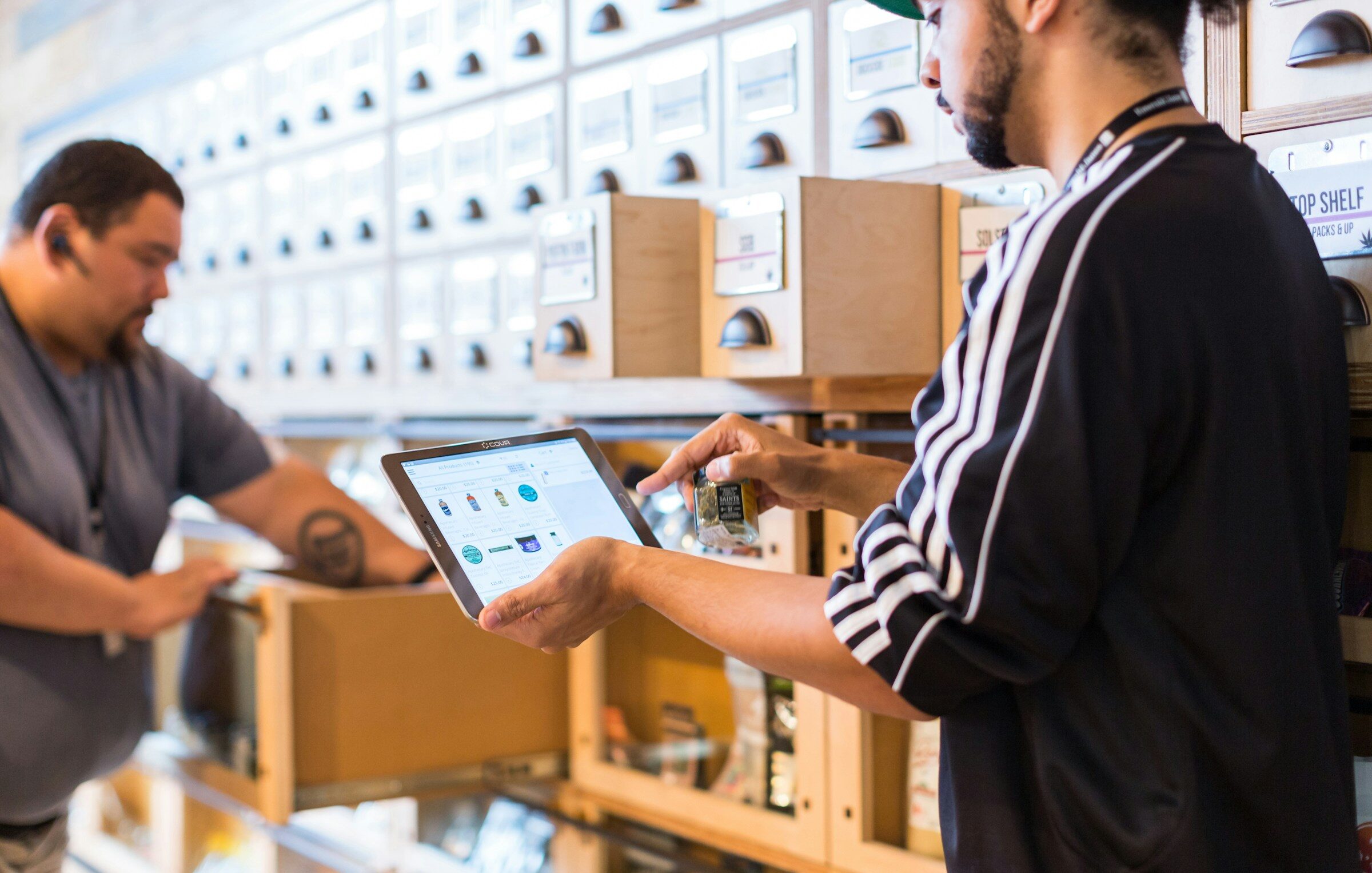 Two people in a shop checking stock on a tablet