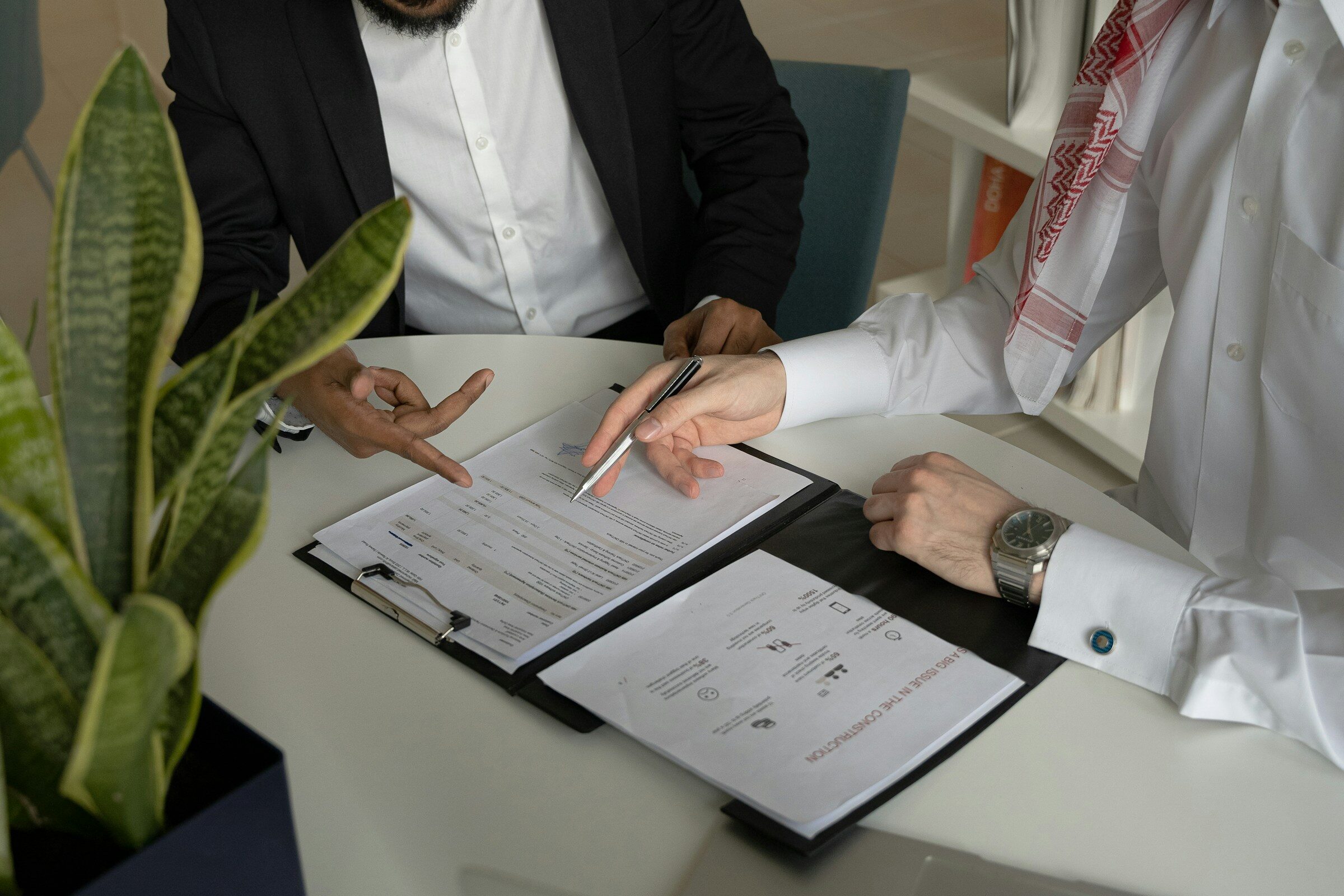 Two people going through paperwork with a pen